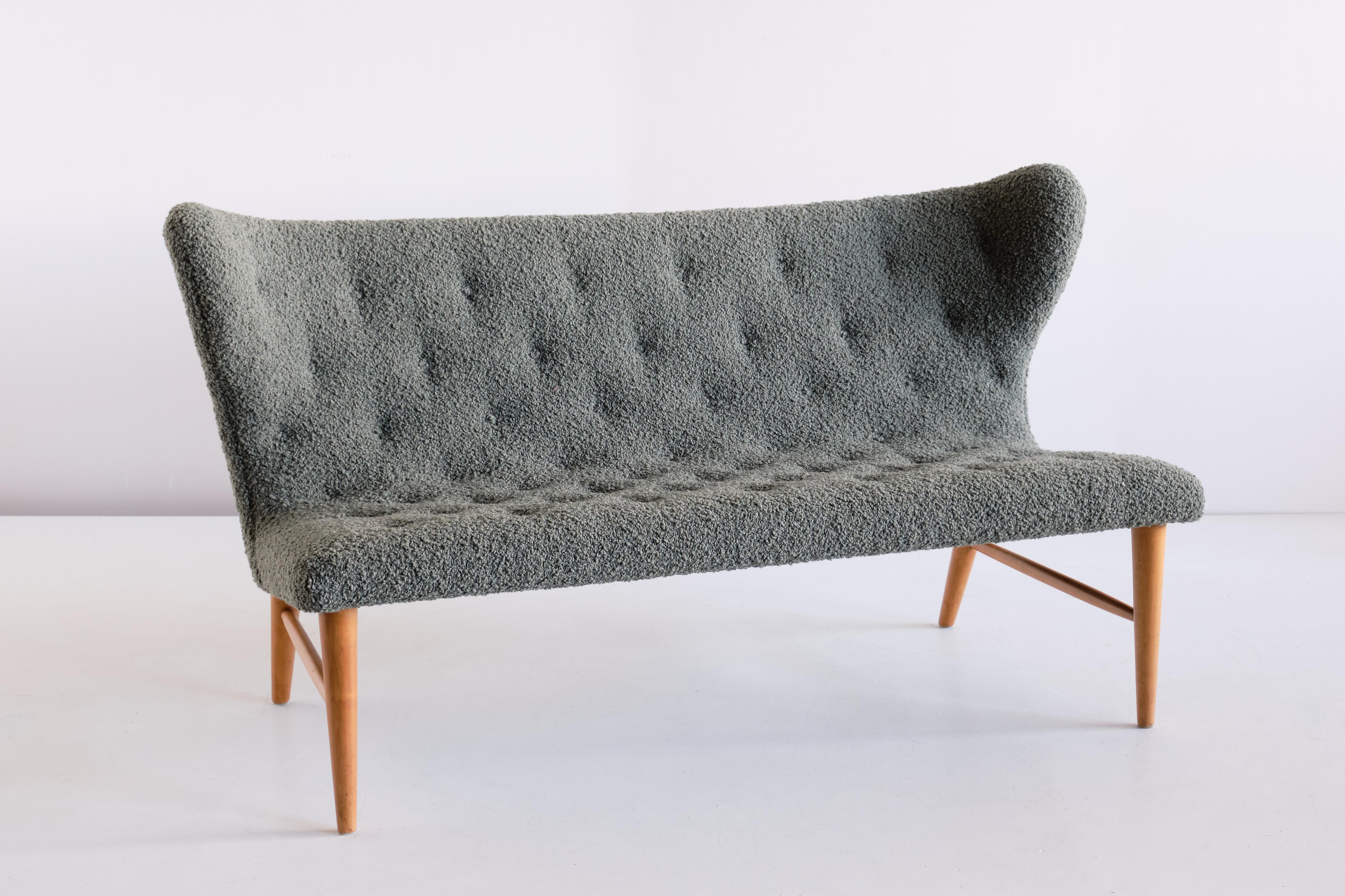 This rare sofa was designed by Eric Bertil Karlén and produced by his company Firma Rumsinteriör in Sweden in the 1940s. The elegant shape of the design is emphasized by the buttoned wing shaped back and seat. The solid beech frame consists of