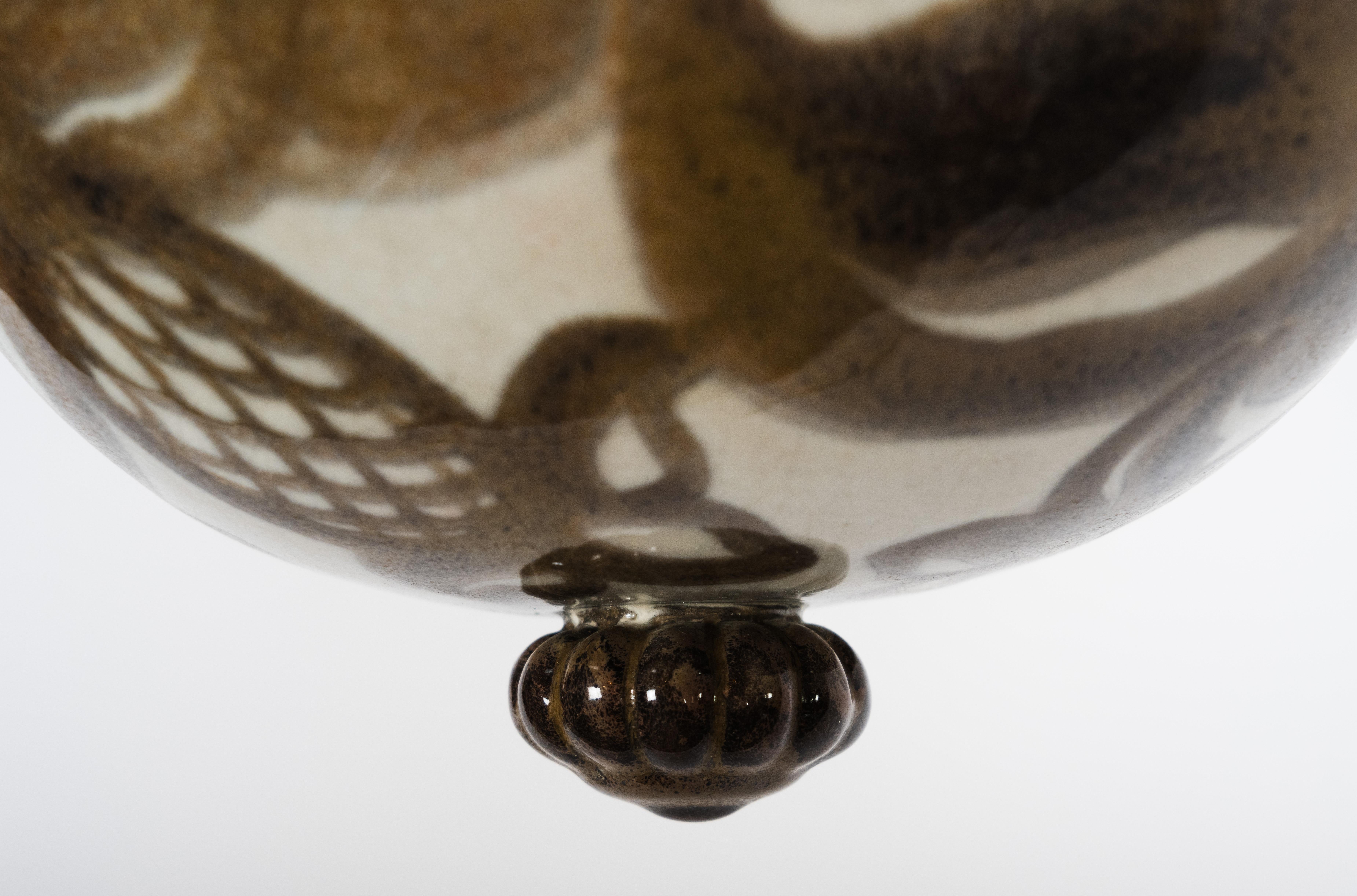 A two-tiered pendant light designed by Swedish artist Edgar Böckman (1890-1981) for Hoganas. Made of two Earthenware discs with pineapple motifs and striping suspended on three silk wire rope cords. Circa 1930s.