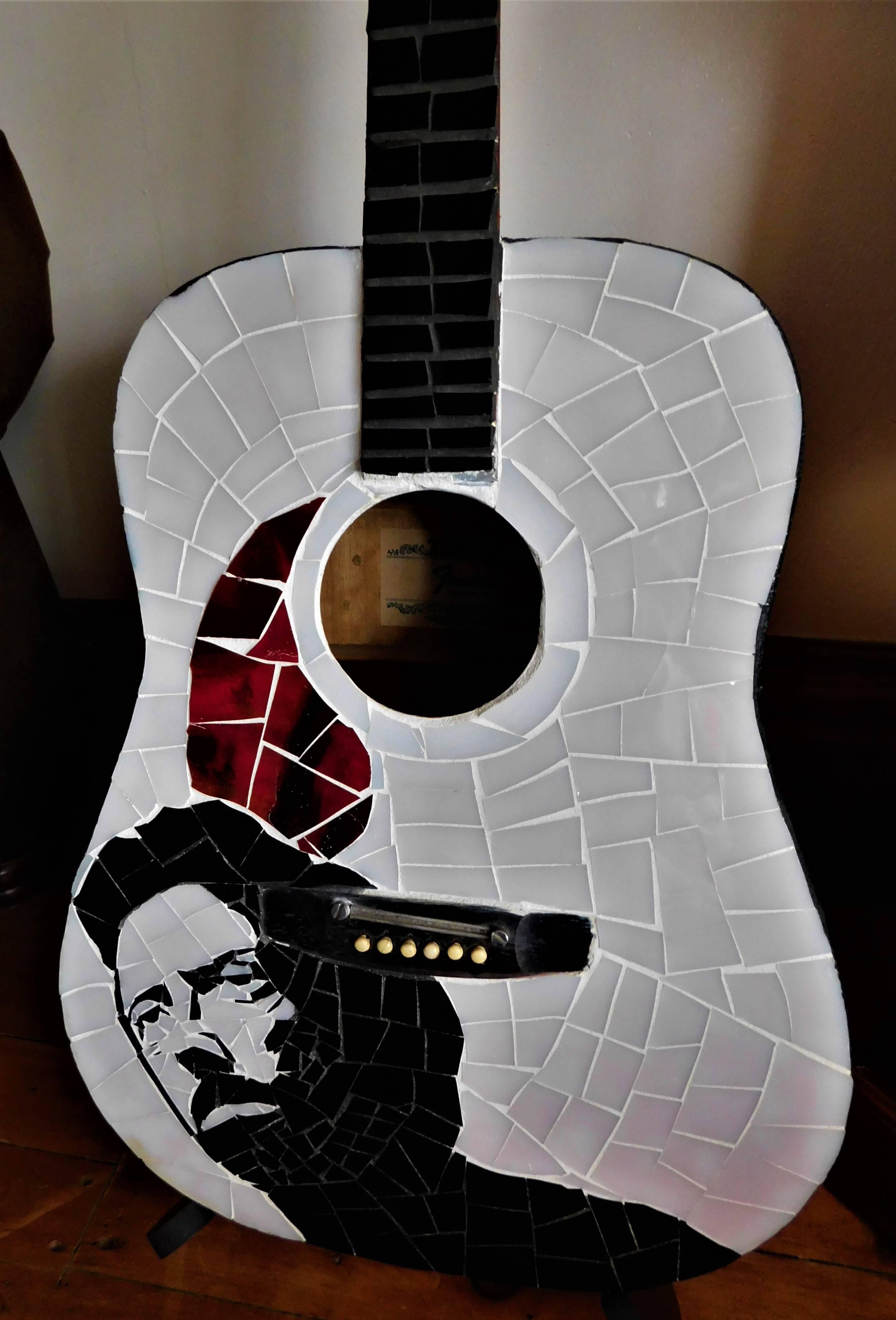 This Eric Clapton stained glass acoustic guitar was created by Brantford, Ontario, Canada artist Lily Crawford in 2012, signed on the back. The neck has black stained glass all the way up it and the sides and back are covered with gold leaf. It can