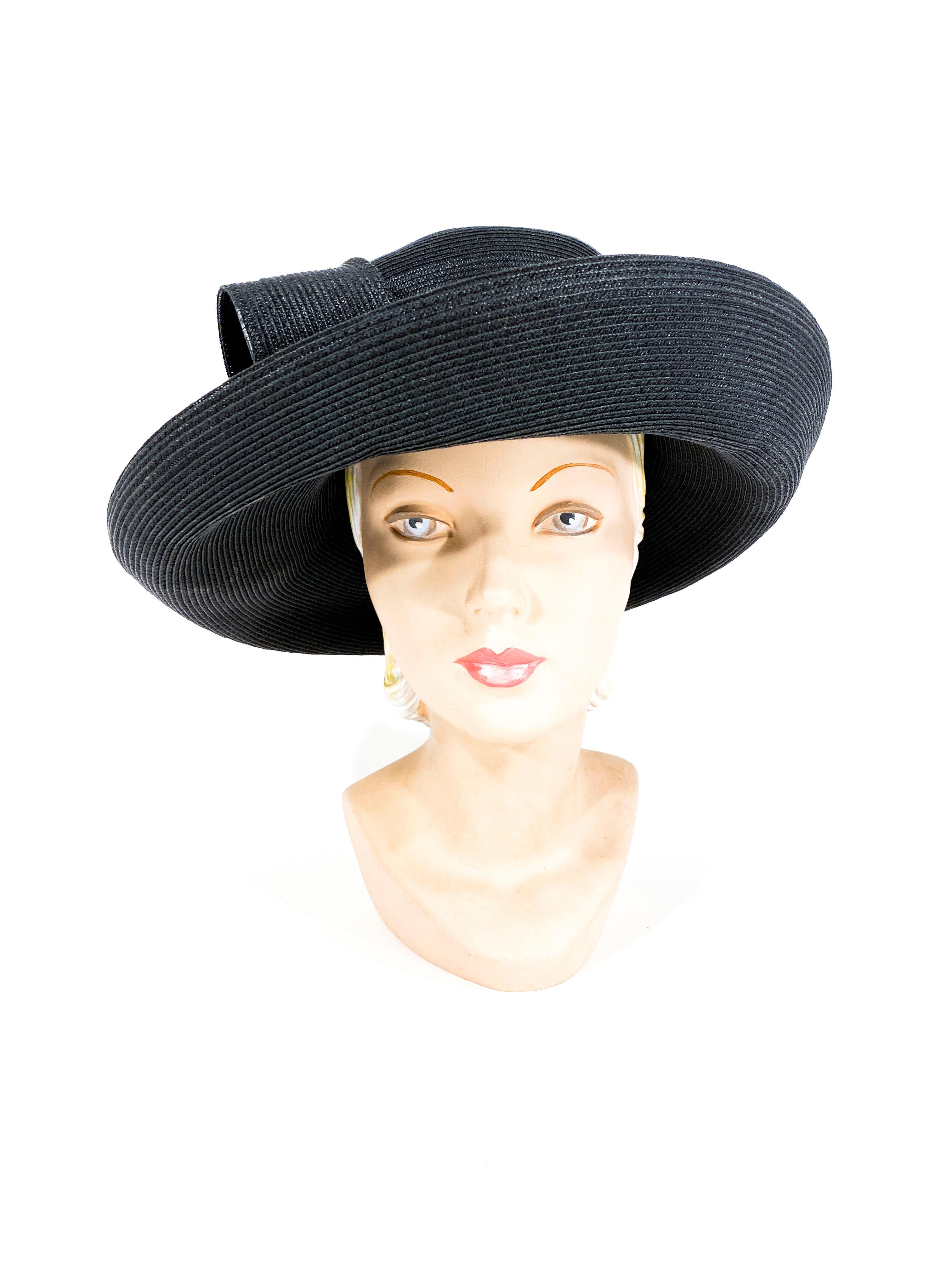 1980s to 1990s black coated straw woven hat with a tall crown, wide curled brim, and an oversized structured bow along the wide matching hatband. 