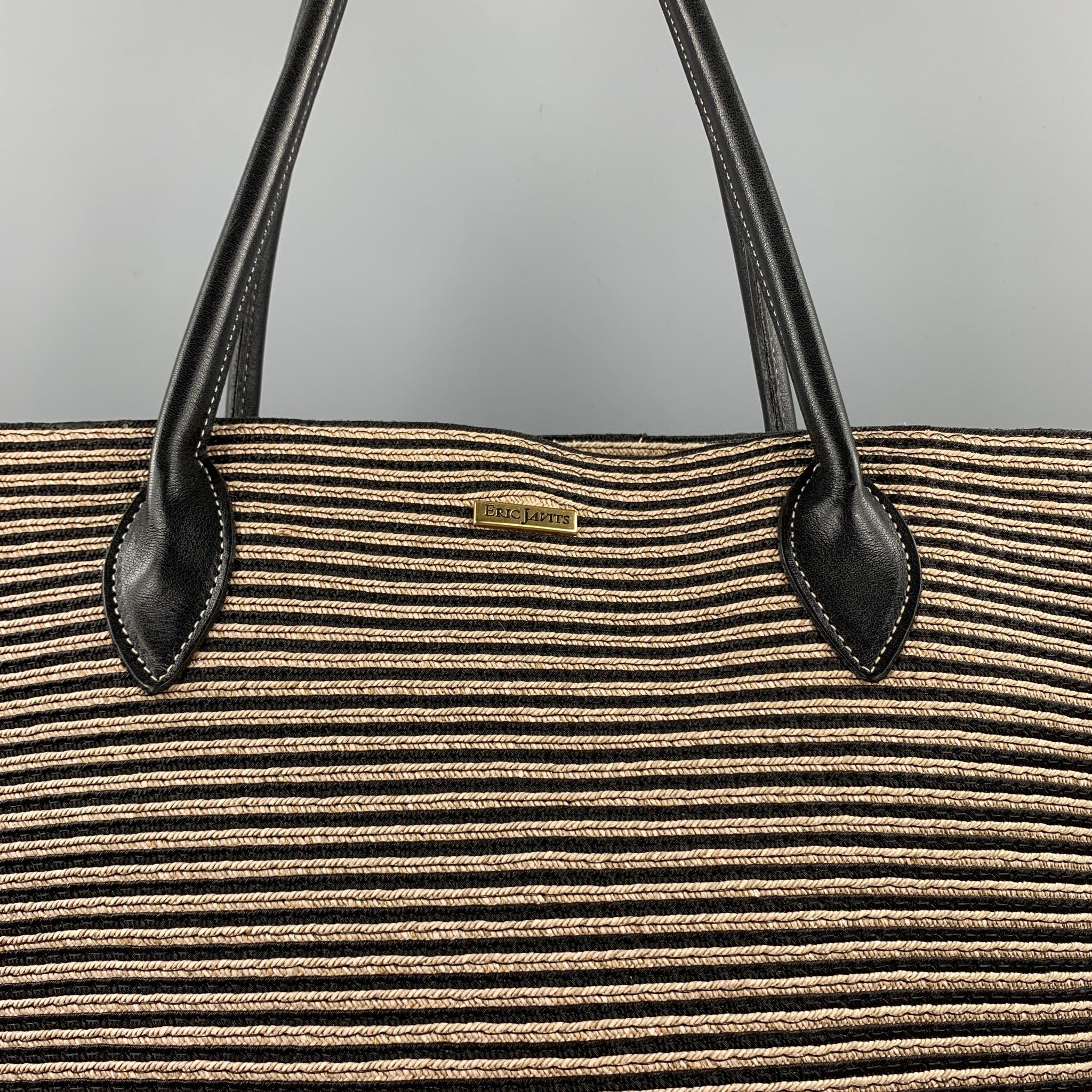 ERIC JAVTIS handbag comes in a black & beige straw with leather trim top handles featuring a tote style, red interior, one inner slot, and a magnetic snap button closure. 

Very Good Pre-Owned Condition.

Measurements:

Length: 10.5 in.
Width: 3.5