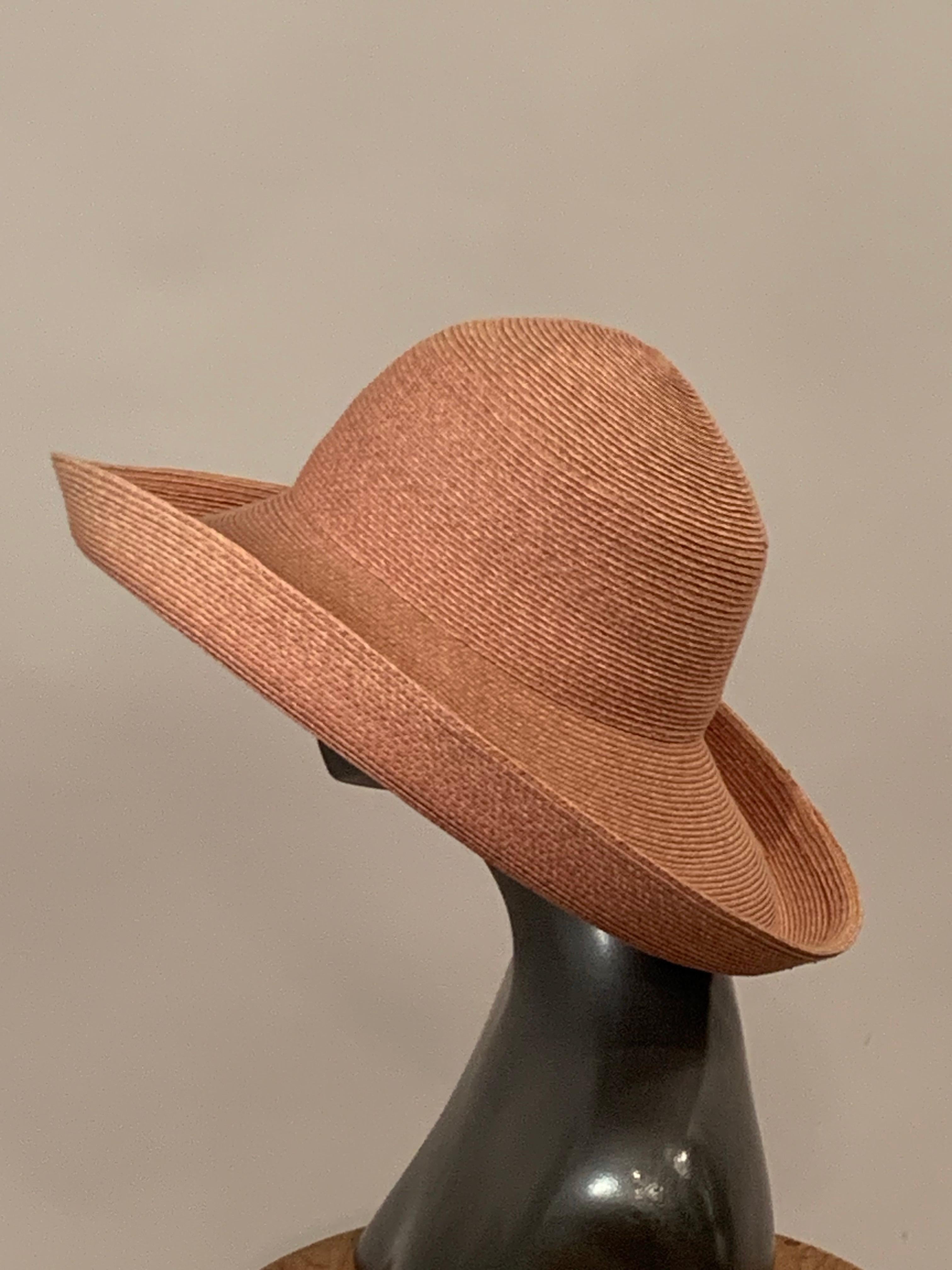 Questo cappello di Eric Javits è realizzato in pregiata paglia naturale e può essere facilmente abbellito o abbassato a seconda dell'occasione.  L'ampia tesa è risvoltata su tutto il perimetro e il cappello è in ottime condizioni.
Circonferenza