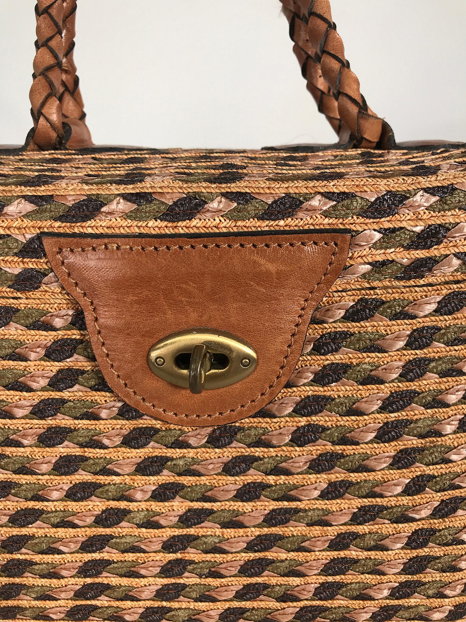 Eric Javits woven raffia, cord & leather handbag. Tightly woven and sewn the bag is done in subtle colours of moss & forest green, tan & cocoa with a braided saddle tan handle and attachments at bag top. The bag has a fitted top and closes at the