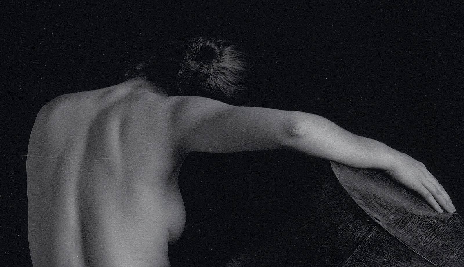 Akt mit Zinkgefäß (Rückenblick auf eine nackte Frau, die ein Zinkobjekt in der Hand hält) – Photograph von Eric Kellerman (b. 1944)
