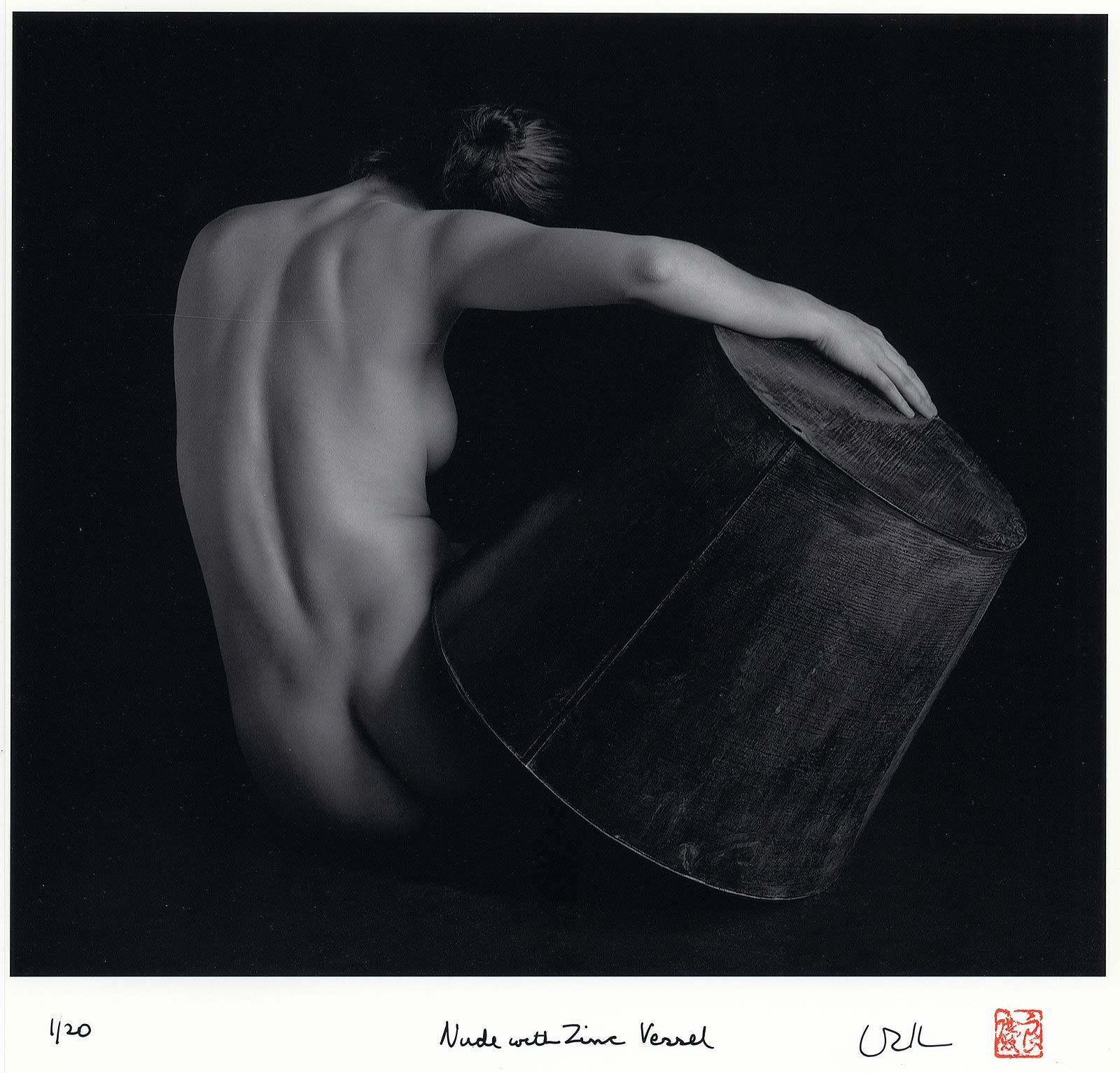 Akt mit Zinkgefäß (Rückenblick auf eine nackte Frau, die ein Zinkobjekt in der Hand hält) (Schwarz), Nude Photograph, von Eric Kellerman (b. 1944)