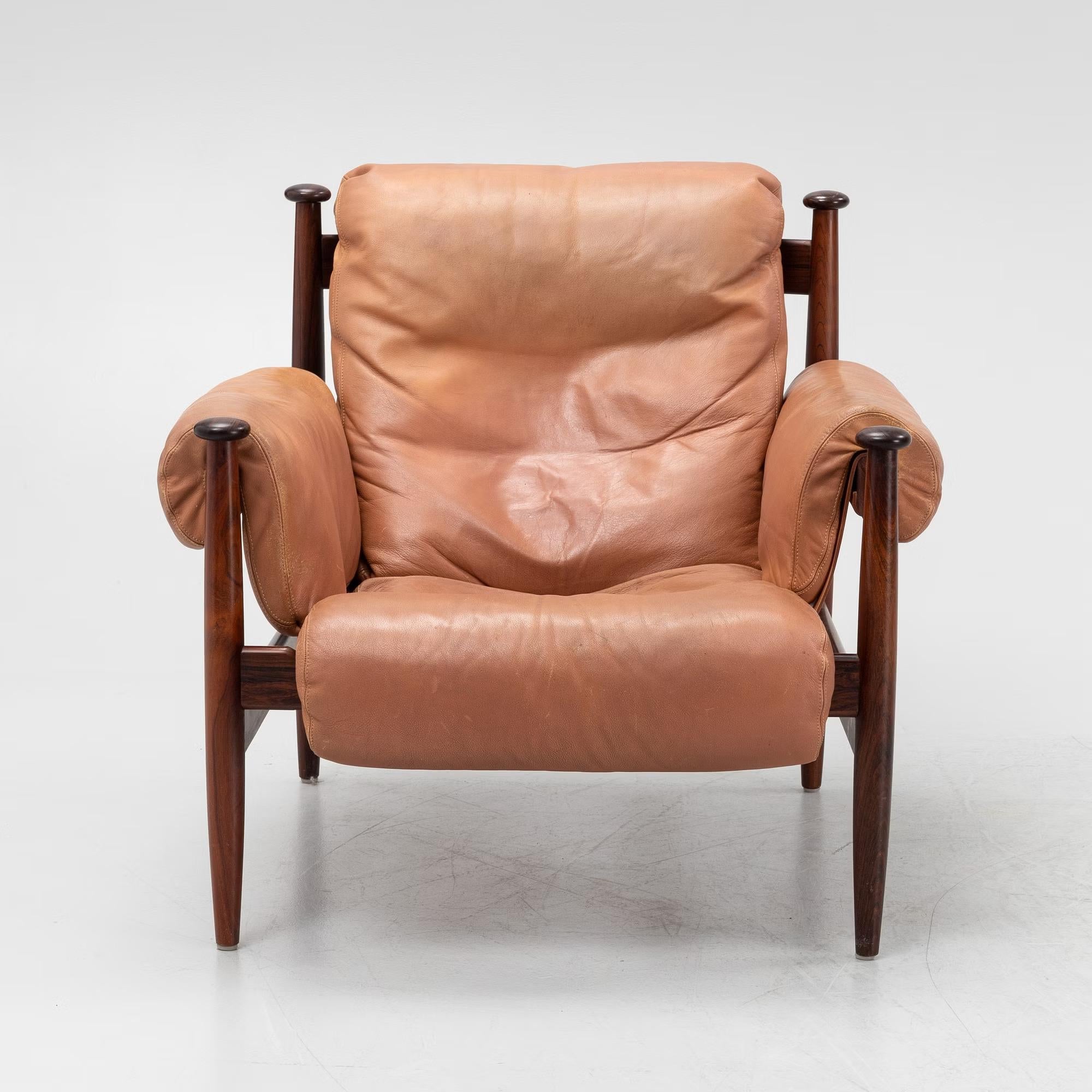 Armiral chair designed by Eric Merthen for Ire Mobel Sweden in the 1960s. 
The chair has a beautiful rosewood frame and is upholstered in the original light brown leather. 
The cushion is supported by leather straps with brass details. 
This chair