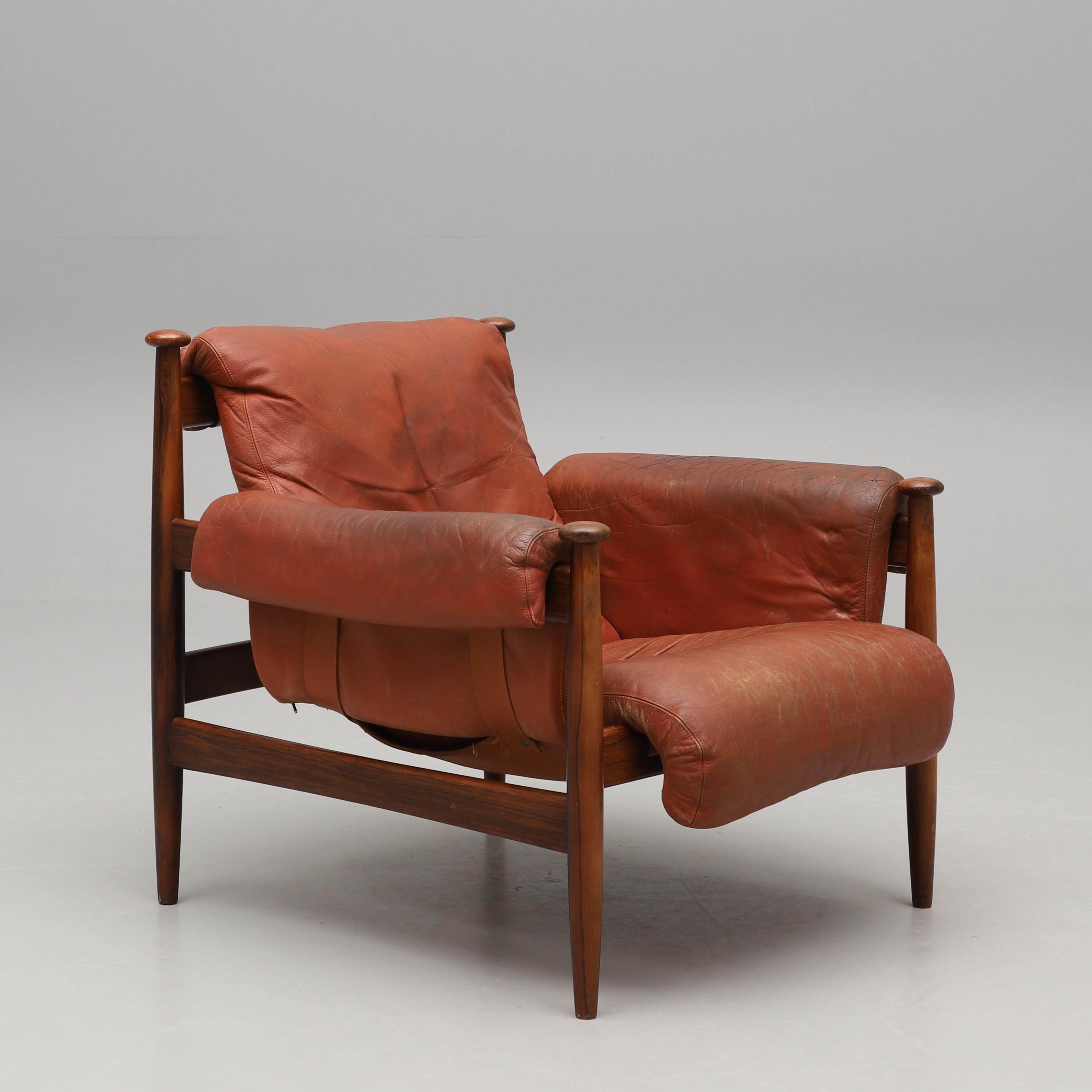 Armiral Stuhl mit Fußhocker, entworfen von Eric Merthen für Ire Mobel Sweden in den 1960er Jahren. Der Stuhl hat einen schönen Palisanderrahmen und ist mit dem originalen Cognacleder bezogen. Das Kissen wird von Lederriemen mit Messingdetails