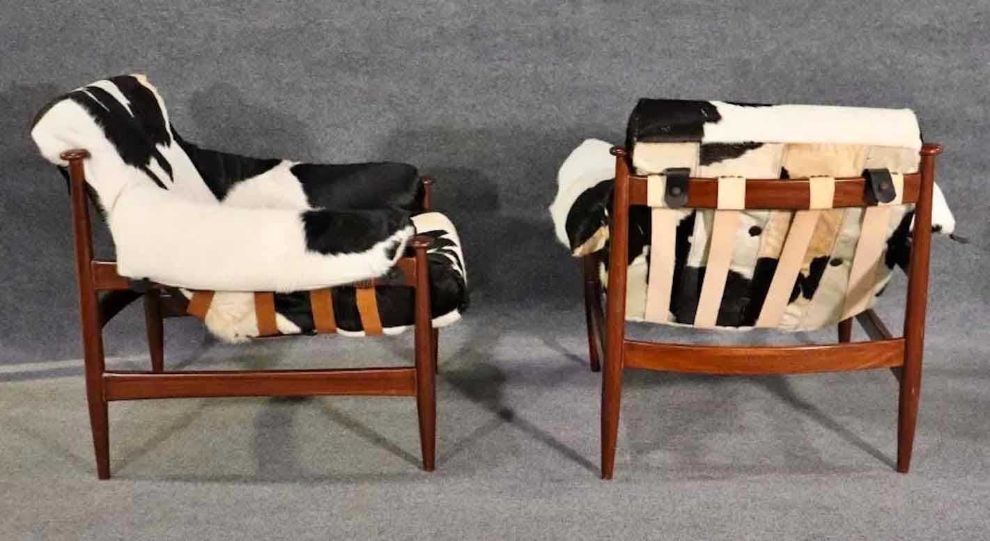 Pair of vintage arm chairs with hide seats on leather straps. Great mid-century design with black and white flair.
Please confirm location.