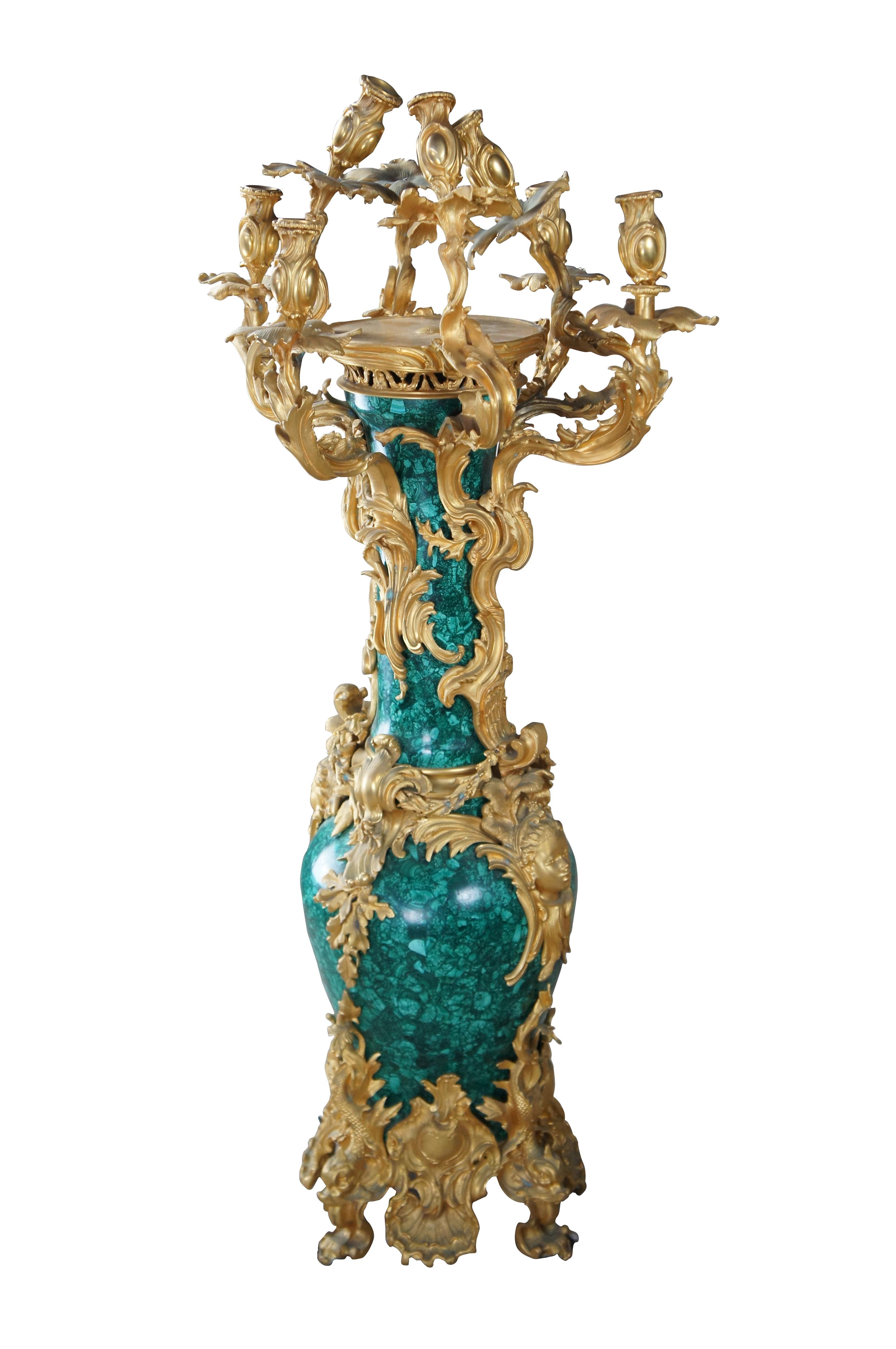 An elaborate monumental Baroque Rococo style vase and candelabra by Eric Stepniewski. Features a malachite stone vase wrapped in low relief chiseled 24k gold brass foliate with figural maidens mounted at the center and dolphin (Delphinius) feet