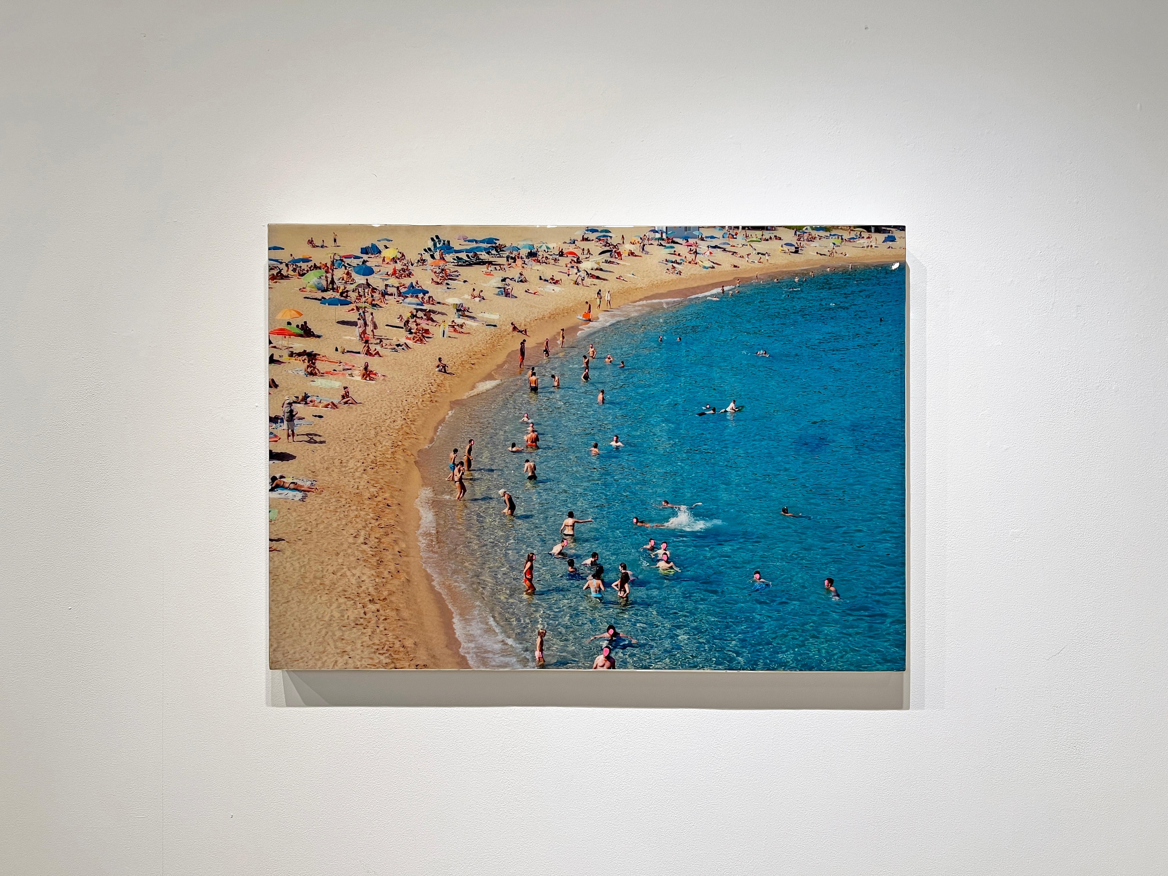 Depicts a sandy beach populated with swimmers and sunbathers. 

Mixed media artwork by Eric Zener. Employing a multi-layered materials process, Zener has combined hand gilding, resin pours, photography, and oil or ink printing, achieving a depth and