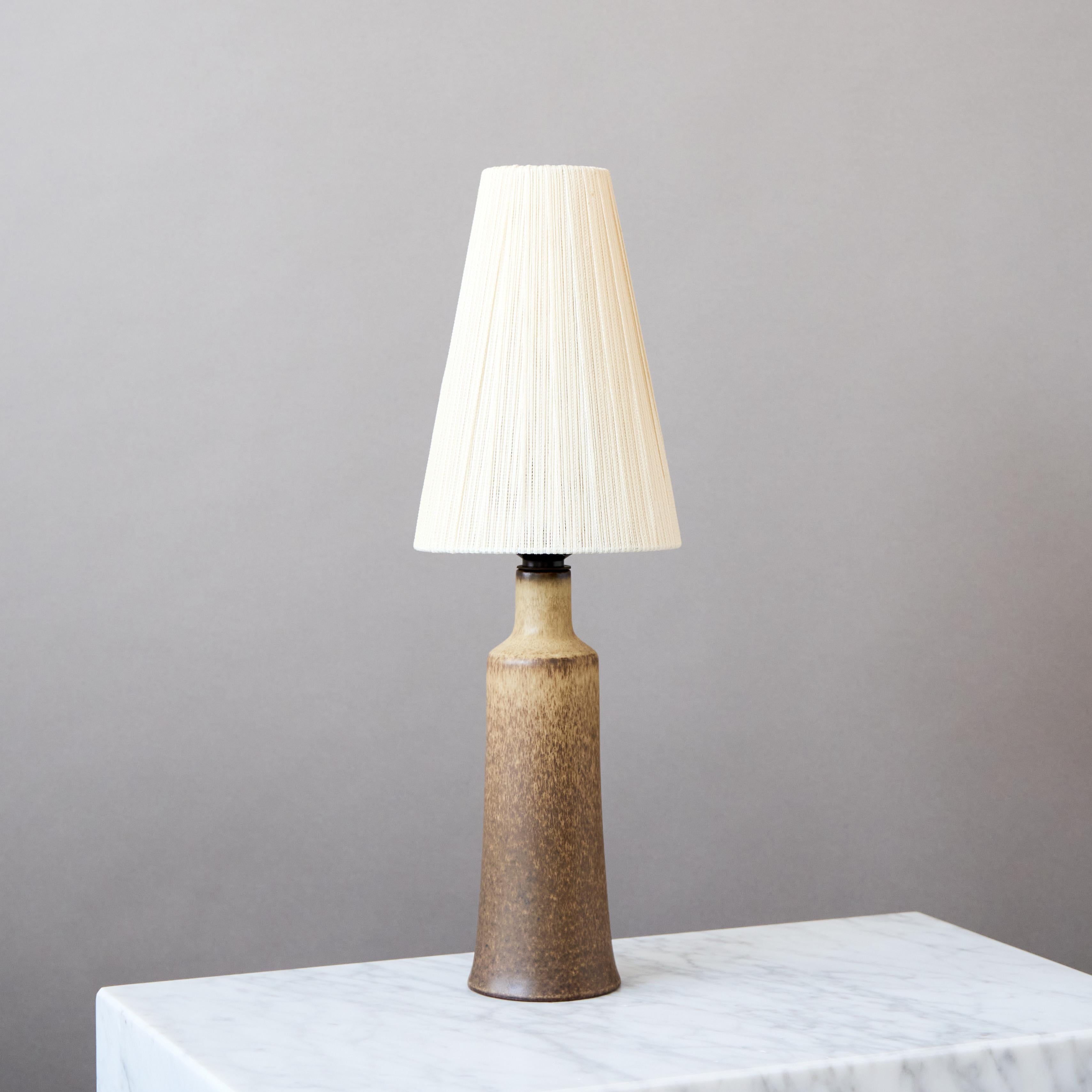 Preciosa lámpara de sobremesa de gres de mediados de siglo con un esmalte asombroso.
Fabricada por los maestros ceramistas Erich and Ingrid Triller en su taller de Tobo, Suecia, años 50.

Excelente estado original.
Firmado en la base con su habitual