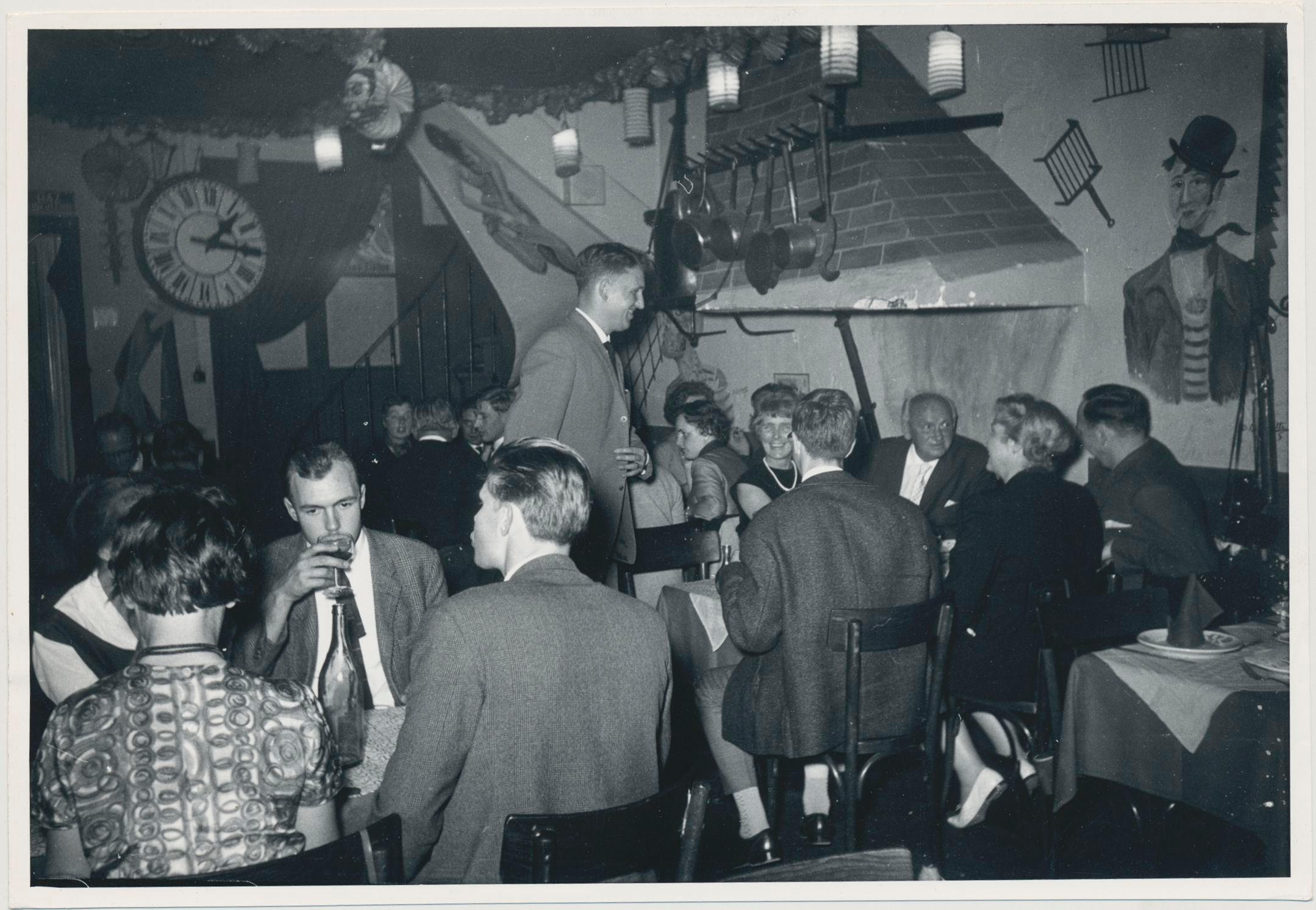Black and White Photograph di Erich Andres - Monmatre, Artisti a cena in un ristorante, Parigi, Francia 1950, 12, 4 x 18 cm