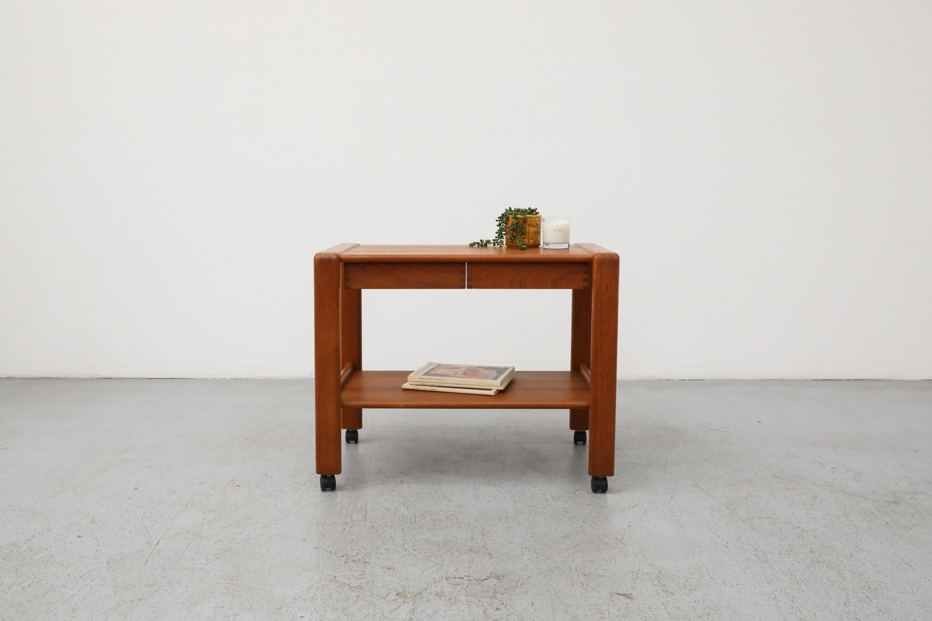 Magnifique chariot roulant en teck danois du milieu du siècle, avec 2 tiroirs. Attribuée au designer Erich Buch, qui a eu une production prolifique au cours de sa collaboration avec le fabricant de la table, Dyrlund-Smith S/A. Fabriquée dans les