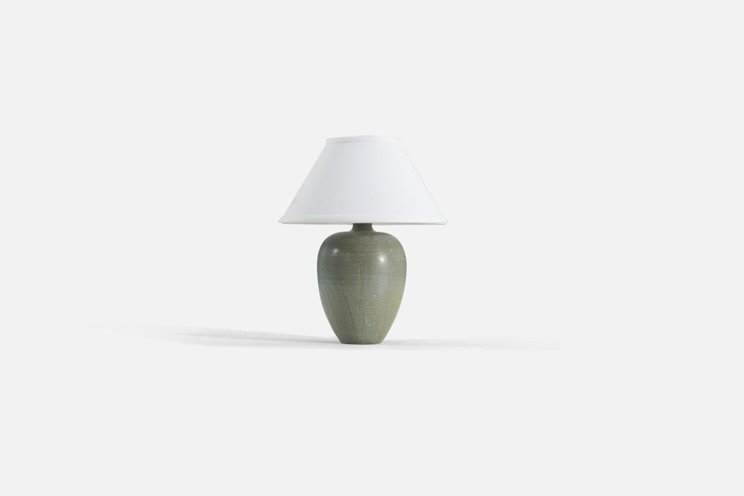 A green-glazed stoneware table lamp designed by Erich & Ingrid Triller, produced in their own studio Tobo, Sweden, c. 1950s.

Sold without lampshade. 

Measurements listed are of lamp only. 
Shade : 4.5 x 10.25 x 6
Lamp with shade : 12.5 x