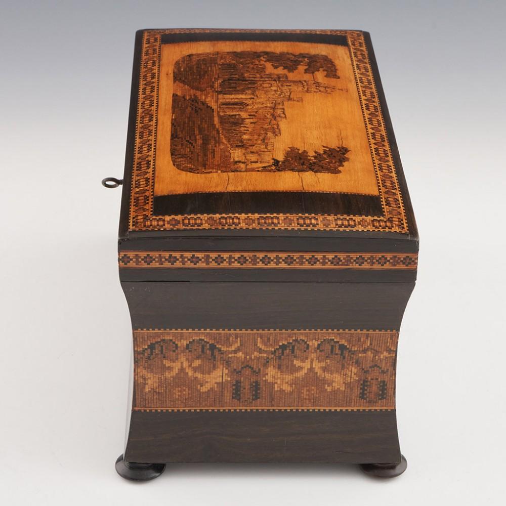 Heading : Two compartment Tunbridge ware tea caddy
Date : c1860
Period : Victoria
Origin : Tunbridge Wells, Kent
Decoration : The cover decorated with Hollamby's version of Eridge Castle within keylines. The cover bordered by a mosaic chain pattern.