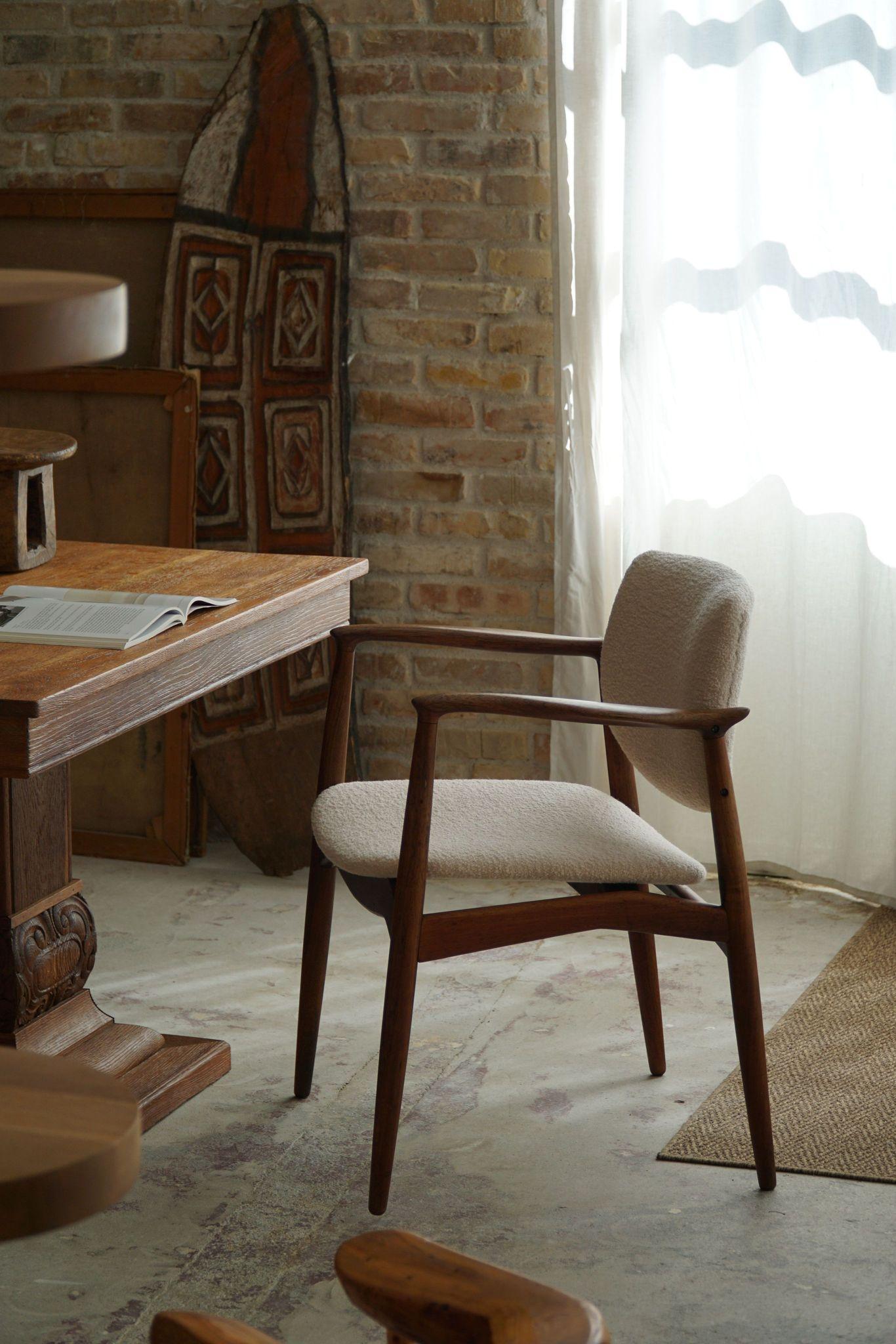 A beautiful Danish modern armchair with gentle curves, called the Captains Chair.
Made in solid rosewood and reupholstered in a luxurious Bouclé, Tiree 1002 (Sand) from BUTE fabric. Made in the 1960s by Erik Buch for Ørum Møbelfabrik (Model 67). The