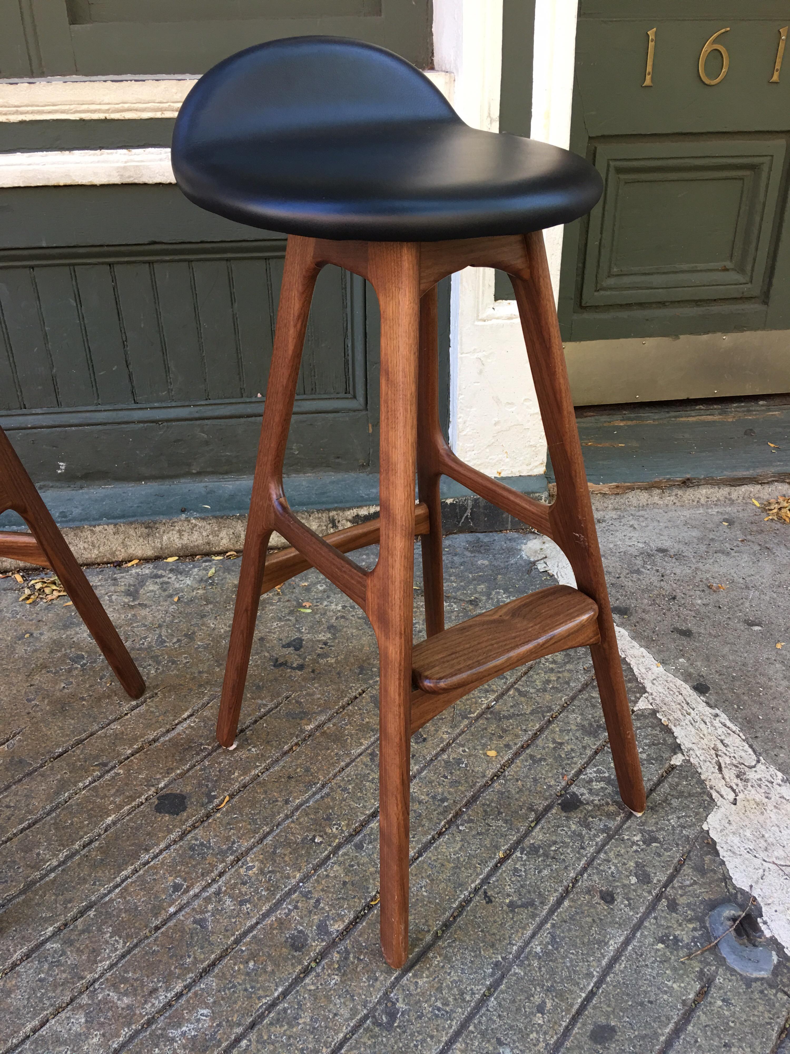 Erik Buch bar stools, set of three with leather seats. Stools are recent production with no markings as to where made. I put them next to a vintage one I have and they match up fine. Leather in great shape! Wood might be mahogany?!