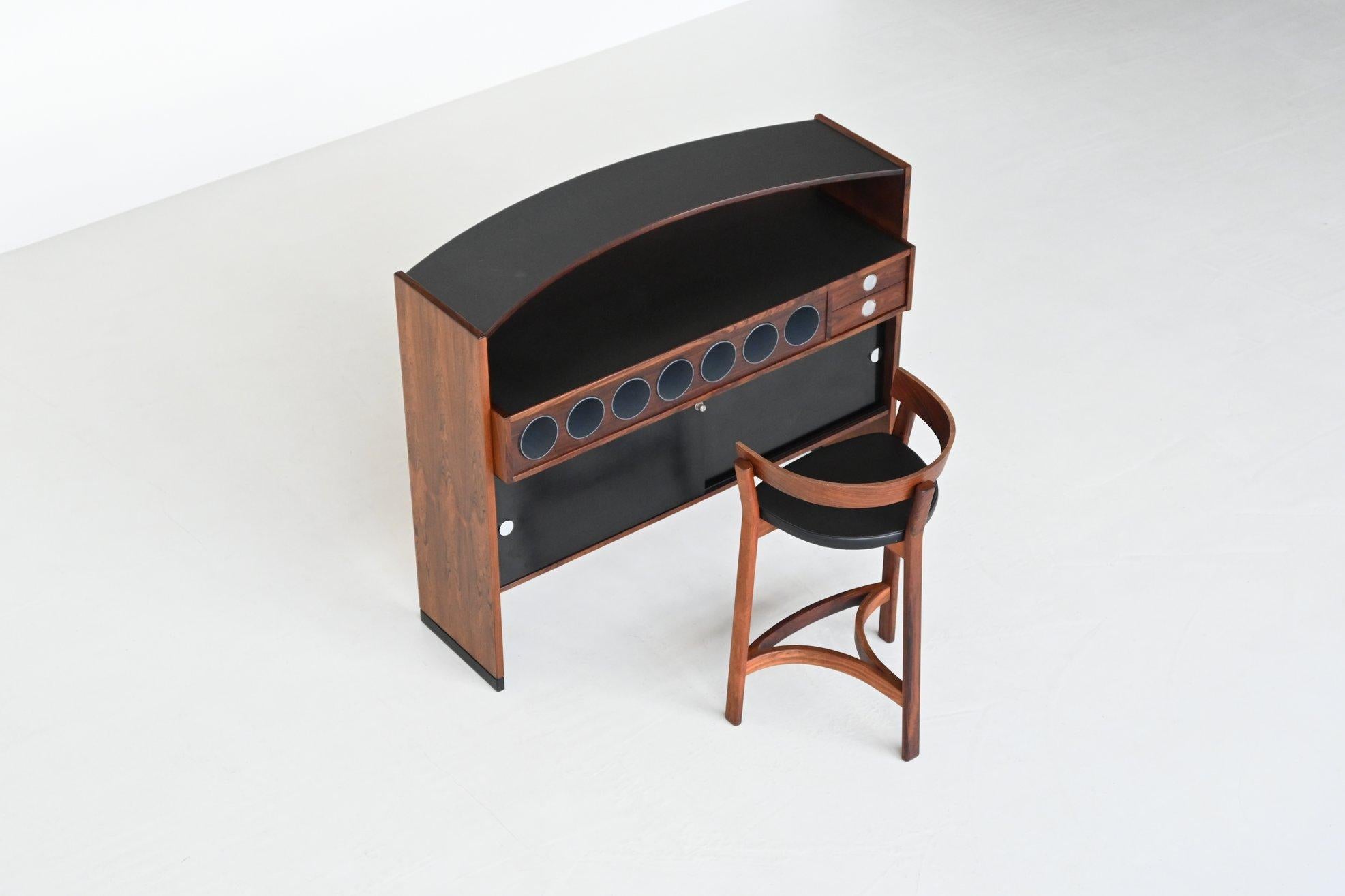 Highly refined freestanding dry bar cabinet with bar stool designed by Erik Buch for Dyrlund, Denmark 1960.

This decorative yet functional liquor bar is executed in beautiful grained rosewood. The bar is boomerang shaped with a chromed steel