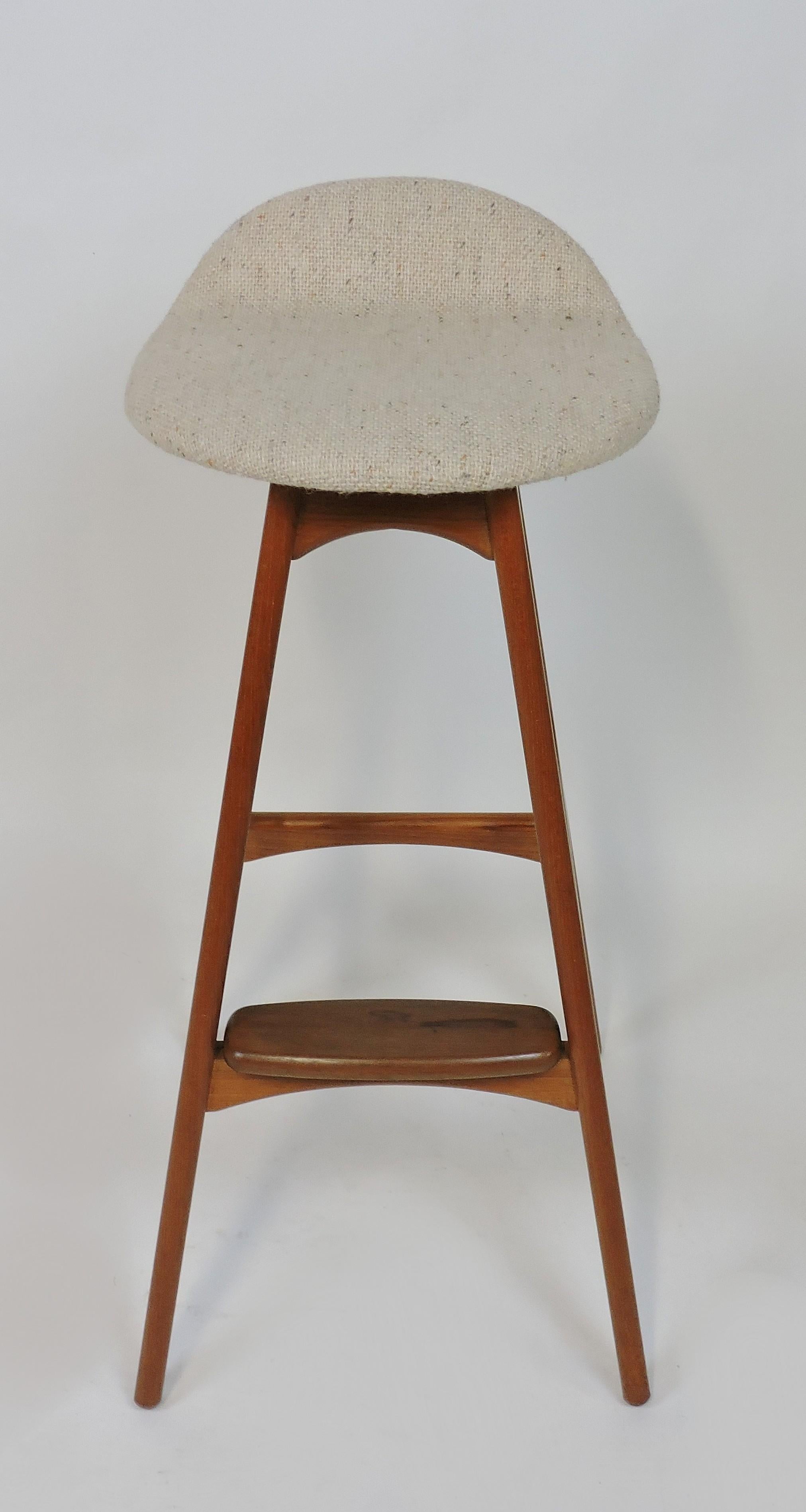 Sleek Danish modern counter stool designed by Erik Buch and made in Denmark by O.D. Mobler. This stool is made of solid sculpted teak and rosewood with a curved seat upholstered in the original beige fleck hopsack fabric. Labeled - Made in Denmark,
