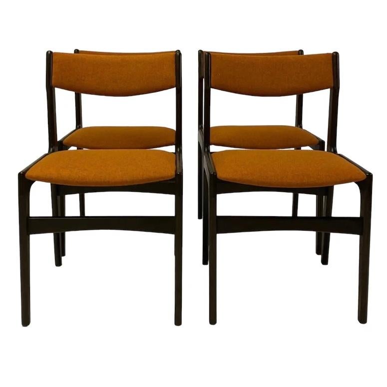 A set of four superb Danish midcentury dining chairs designed by Erik Buch. These dining chairs are highly desirable; & are the epitome of organic lines, tactile curves & stunning wood. The dining chairs are a solid dark wood to the frame & legs.