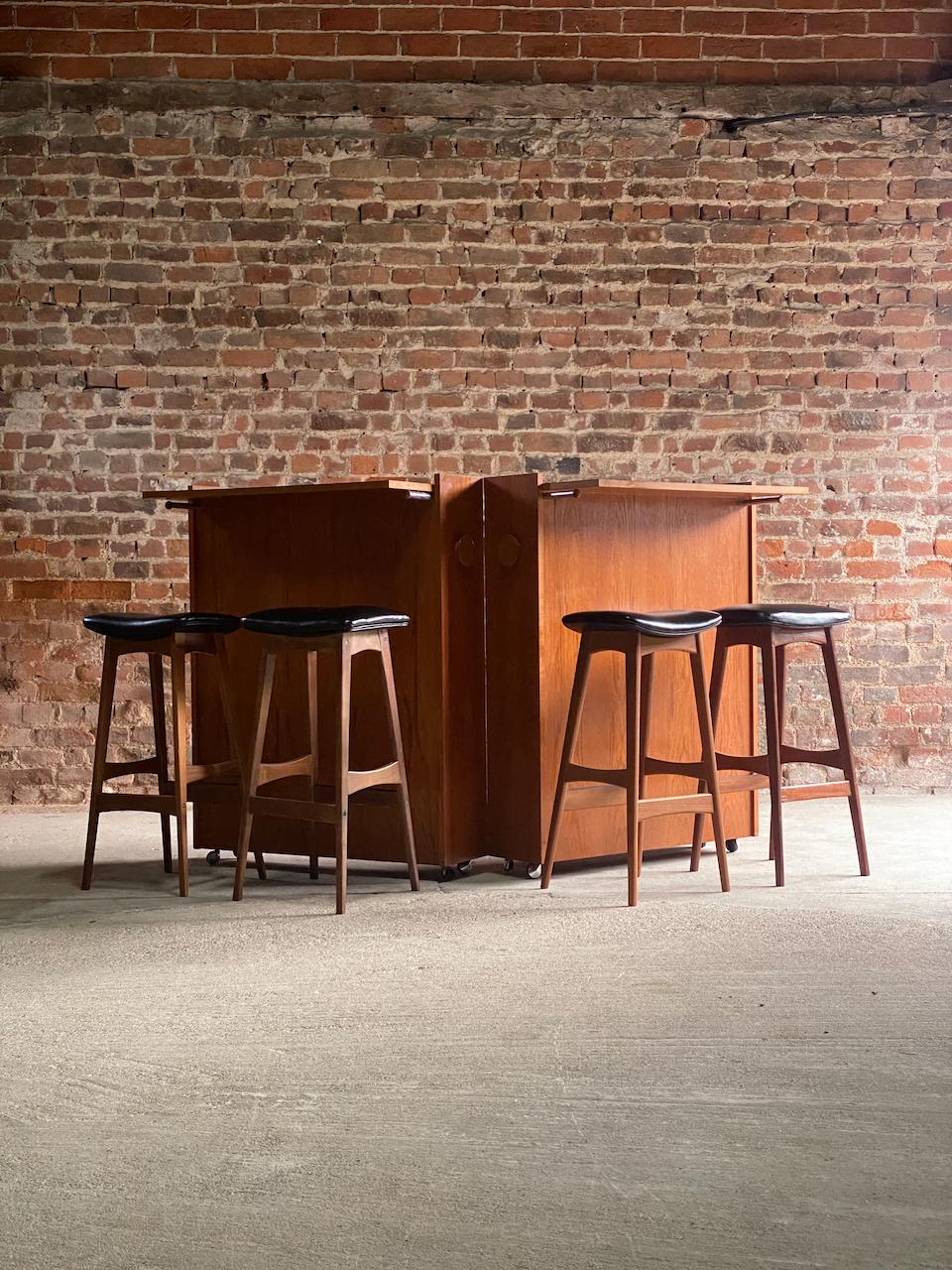 Erik buch drinks bar and barstools by Johannes Andersen, Circa 1960.

Fabulous 1960's mid-century Danish drinks bar also known as the ‘Bar in a Box’ designed by Erik Buch for Dyrlund matched with four solid teak barstools by Johannes Andersen and