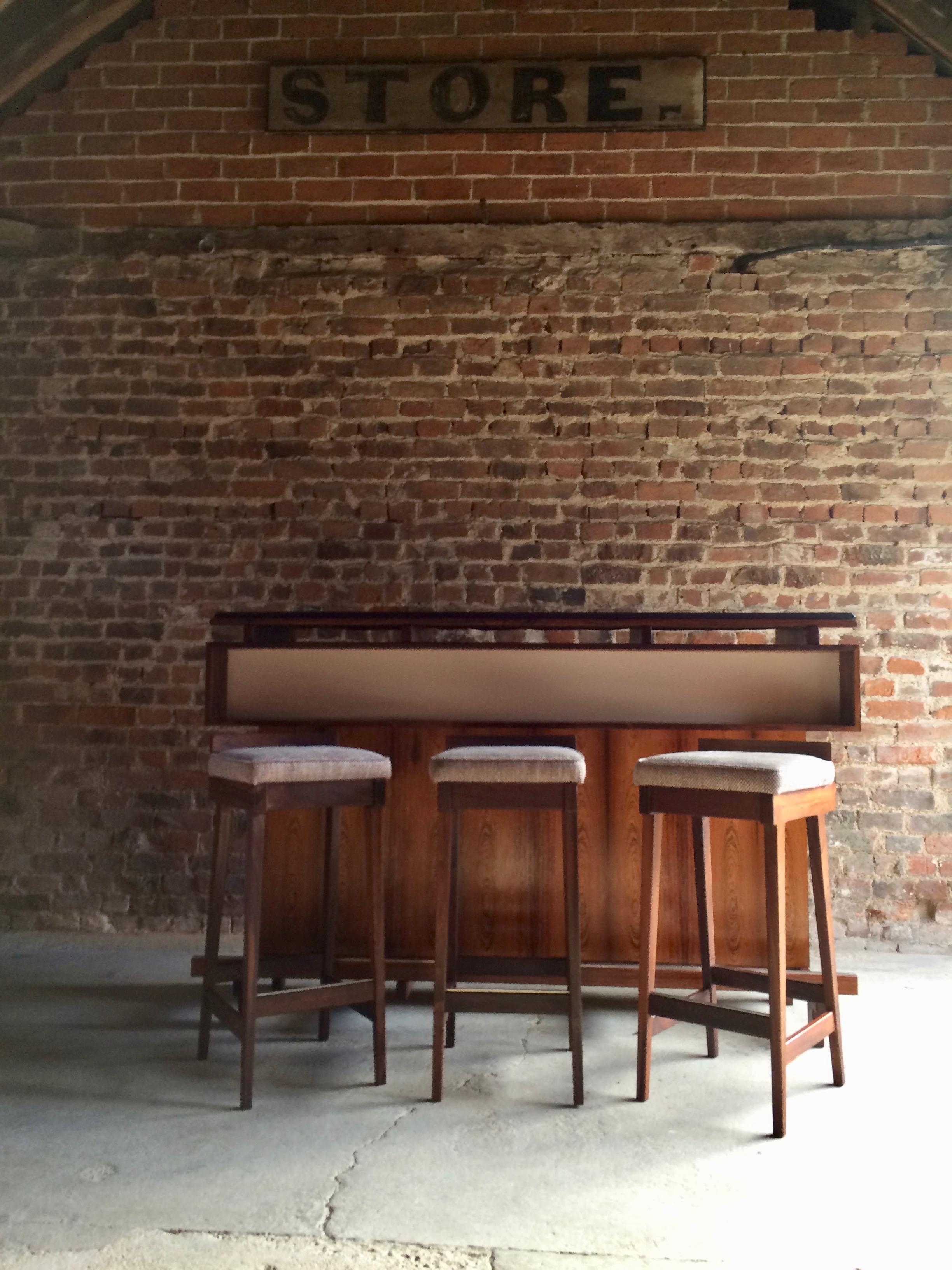 
Magnificent Mid Century Danish Rosewood dry bar by Erik Buch for Dyrlund Denmark 1960’s, the front side of the bar has a recessed white laminate accented shelf with a wonderful full width rosewood frontage with a long solid rosewood and metal