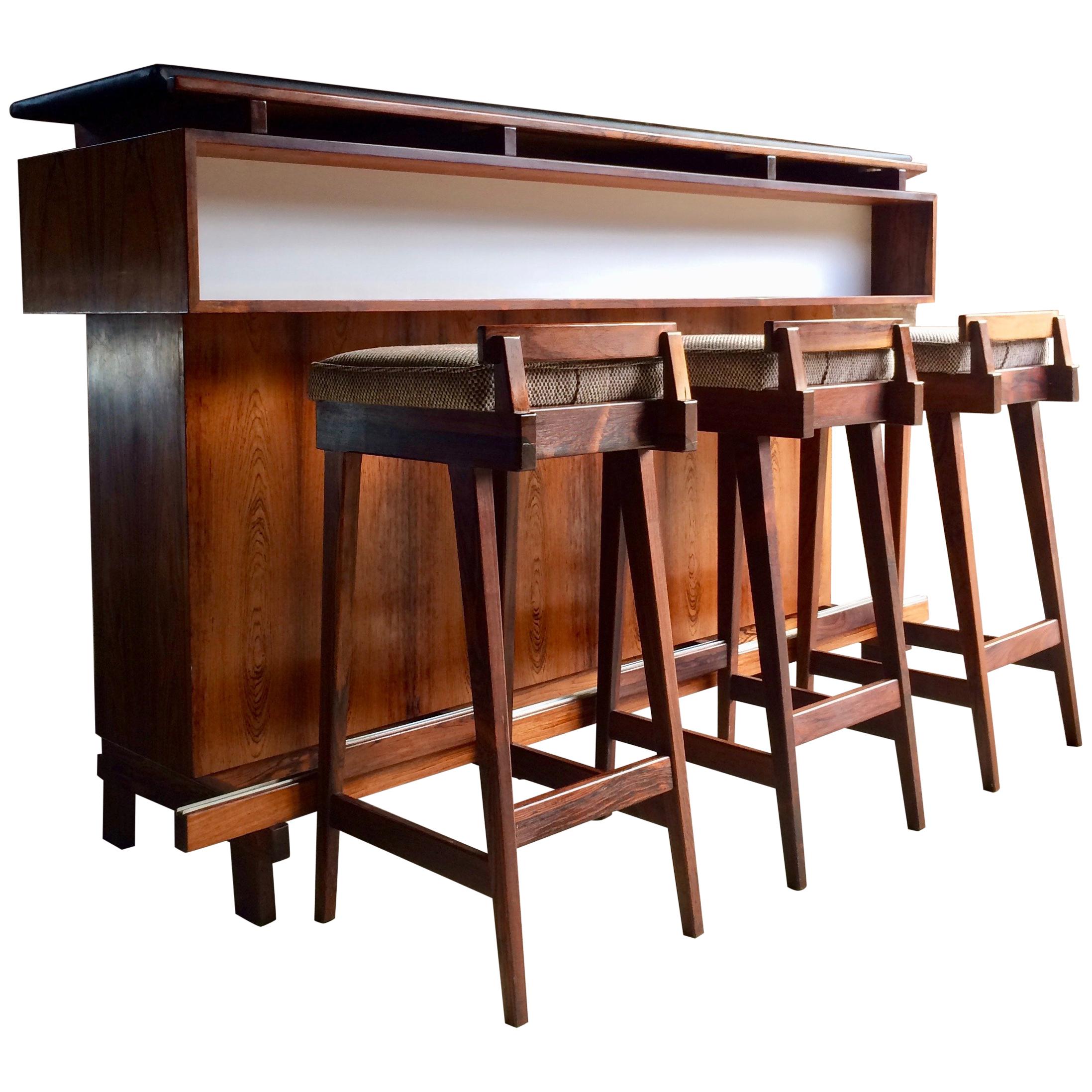 
Magnificent midcentury Danish rosewood dry bar by Erik Buch for Dyrlund Denmark, 1960s, the front side of the bar has a recessed white laminate accented shelf with a wonderful full width rosewood frontage with a long solid rosewood and metal