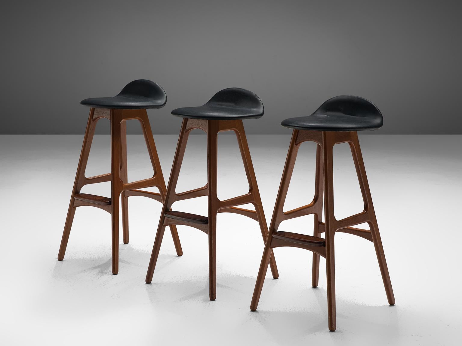 Erik Buch for O.D. Mobler, set of three bar stools, in teak and rosewood and faux leather, Denmark, circa 1960s.

Distinctive set of barstools by Erik Buch (1923-1982). The well crafted frame is in solid teak, with a foot rest in solid rosewood. A