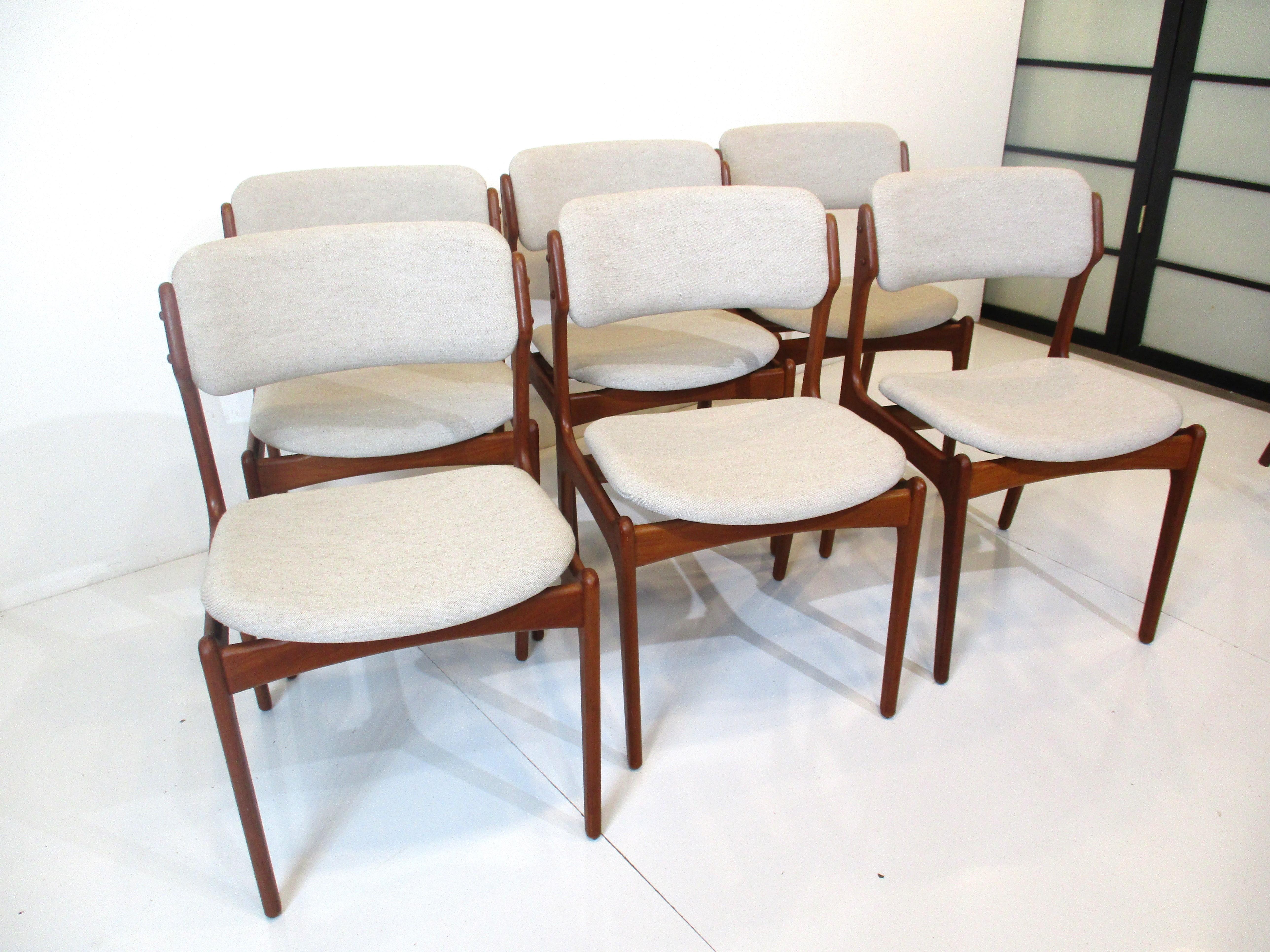 A set of six OD -49 dining chairs with teak wood frames and upholstered backs and seat bottoms. Newly upholstered in a oatmeal toned tight woven contract fabric and designed by Erik Buch for comfort and style manufactured by OD Mobler Denmark.