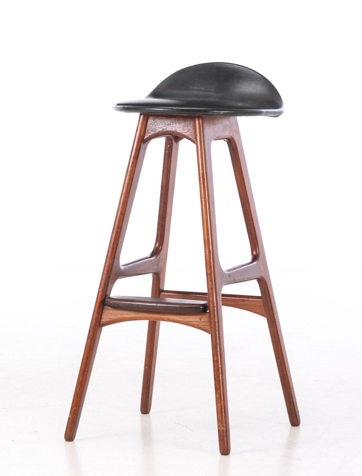 Erik Buck. Bar stool with solid teak frame with footrest, seat upholstered in black leather. Designed in 1965. Seat height 77cm. Manufactured by Oddense Maskinsnedkeri A / S, model OD 61. Appears with normal. age-related traces of use. 
Only one
