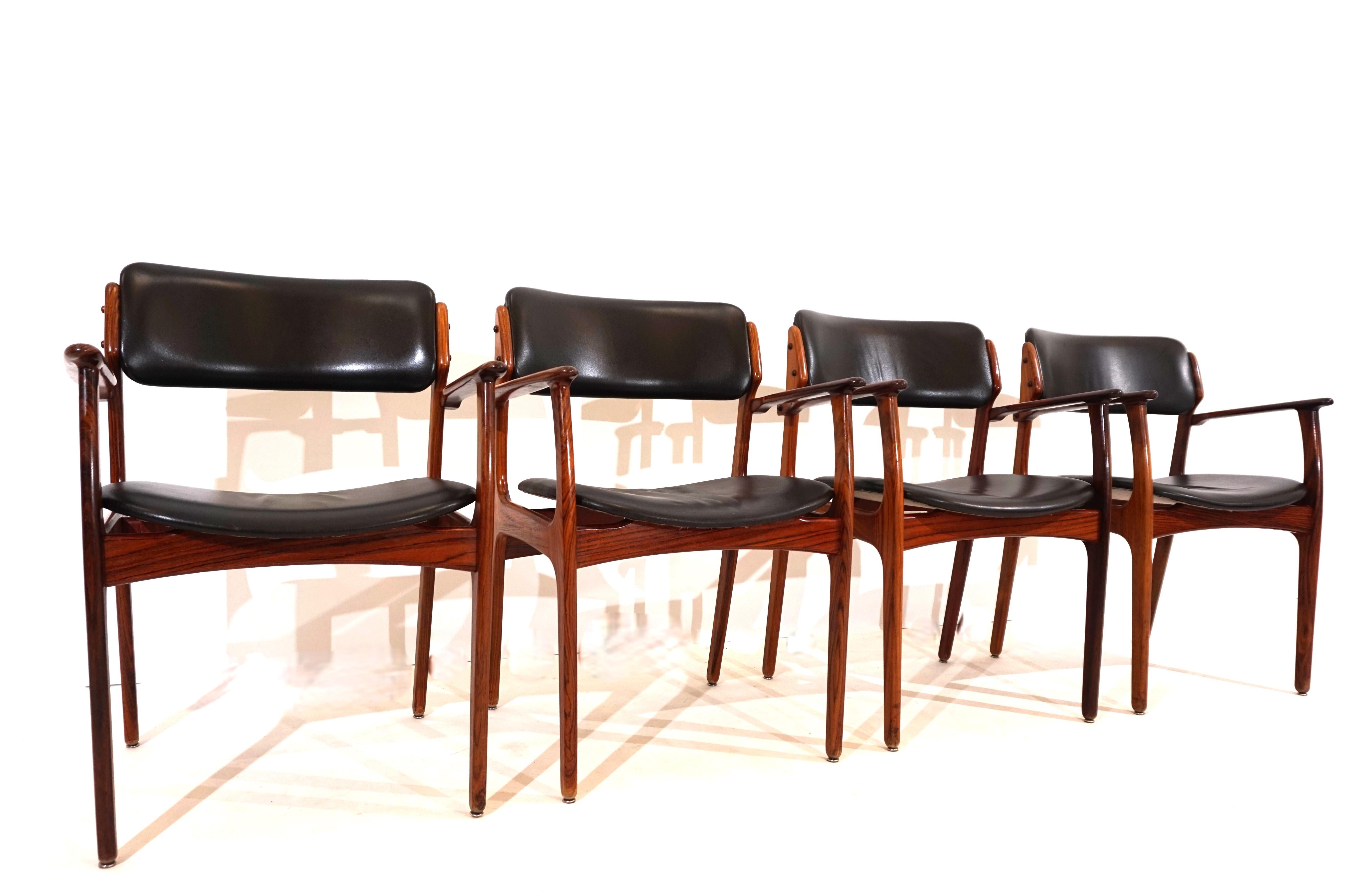 This set of four OD 50 dining room chairs is in great original condition. The rosewood frames with a very attractive grain show minimal signs of wear. The black Skai leather cover of the armchairs only shows slight signs of wear on one of the