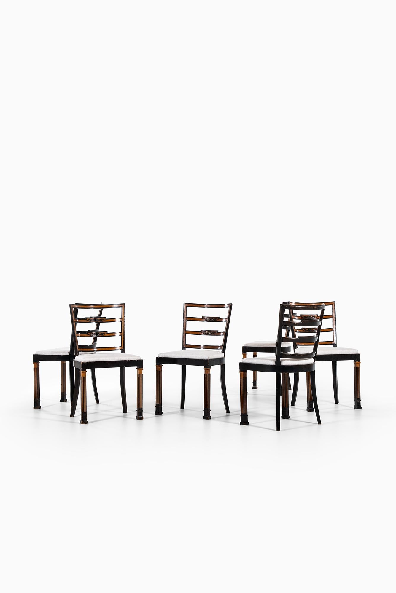 Rare large set of 18 dining chairs designed by Erik Chambert. Produced by Chamberts möbelfabriker in Norrköping, Sweden. Flamed birch. Dark stained and carved birch legs. Newly reupholstered in linen fabric.