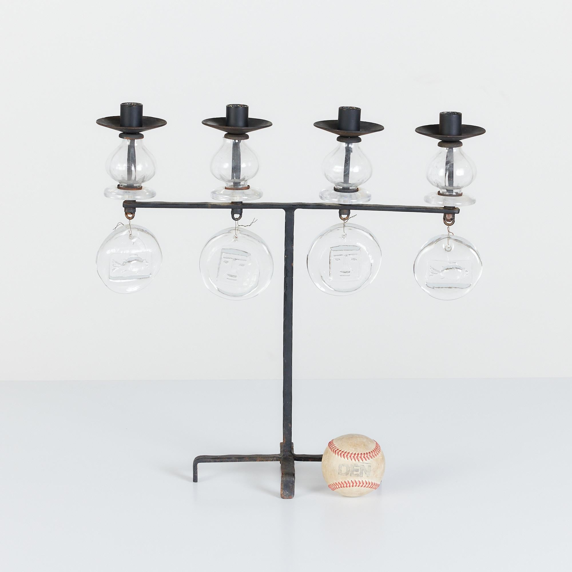 Four arm candelabra by Erik Hoglund for Boda Nova, c.1960s, Sweden. This piece features a wrought iron body with four sprawling feet at the base. Each arm showcases a clear blown glass bulb and Hoglund's signature glass medallions.

Dimensions: