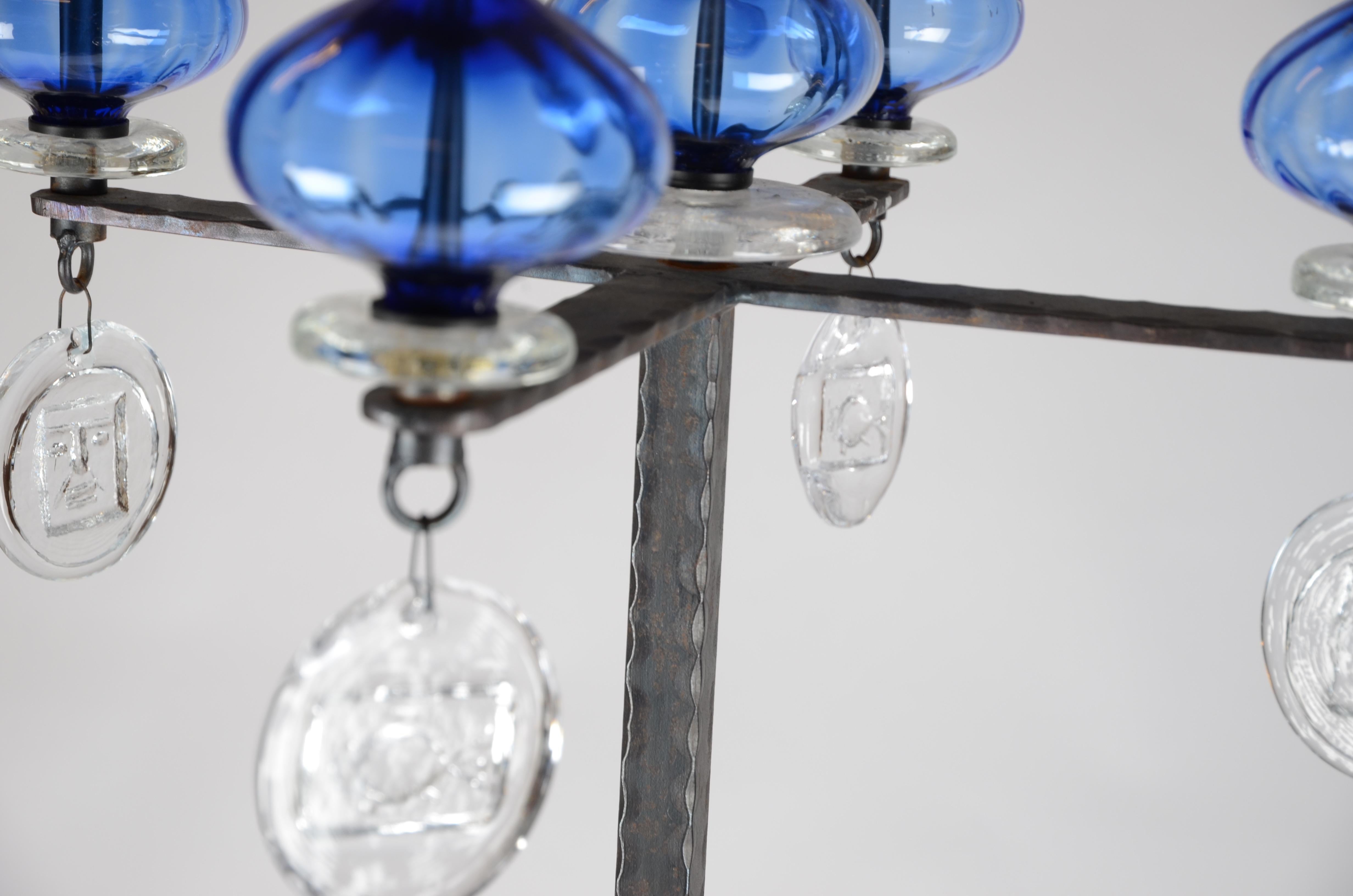 A four-armed floor candelabra, designed by Erik Höglund for Kosta Boda. Made in iron, blue glass and glass with motifs. 1960s-1970s.