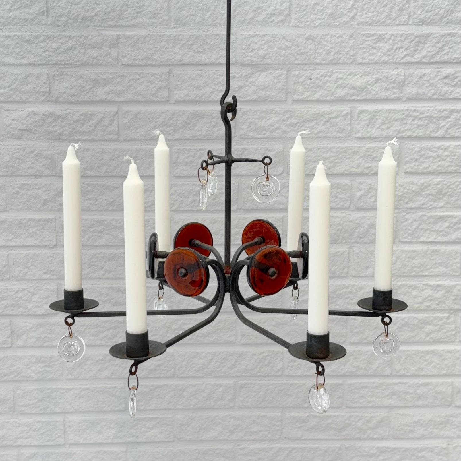 Un elegante lampadario modello SH9 realizzato in ferro e vetro, progettato dall'artista svedese Erik Höglund per Boda Smide. Telaio in ferro rustico con sei portacandele, decorato con diversi prismi di vetro trasparente e quattro dischi di vetro