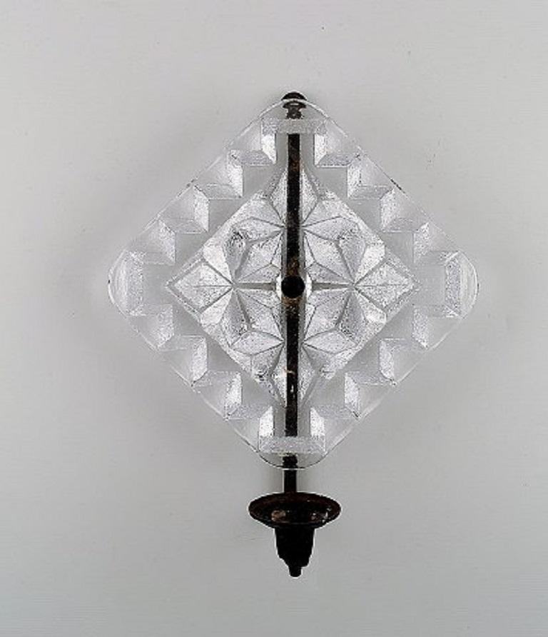 Erik Höglund for Kosta Boda. Two wall candleholders in clear art glass and wrought iron, circa 1970.
Measures: 29 x 23 cm.
In very good condition.