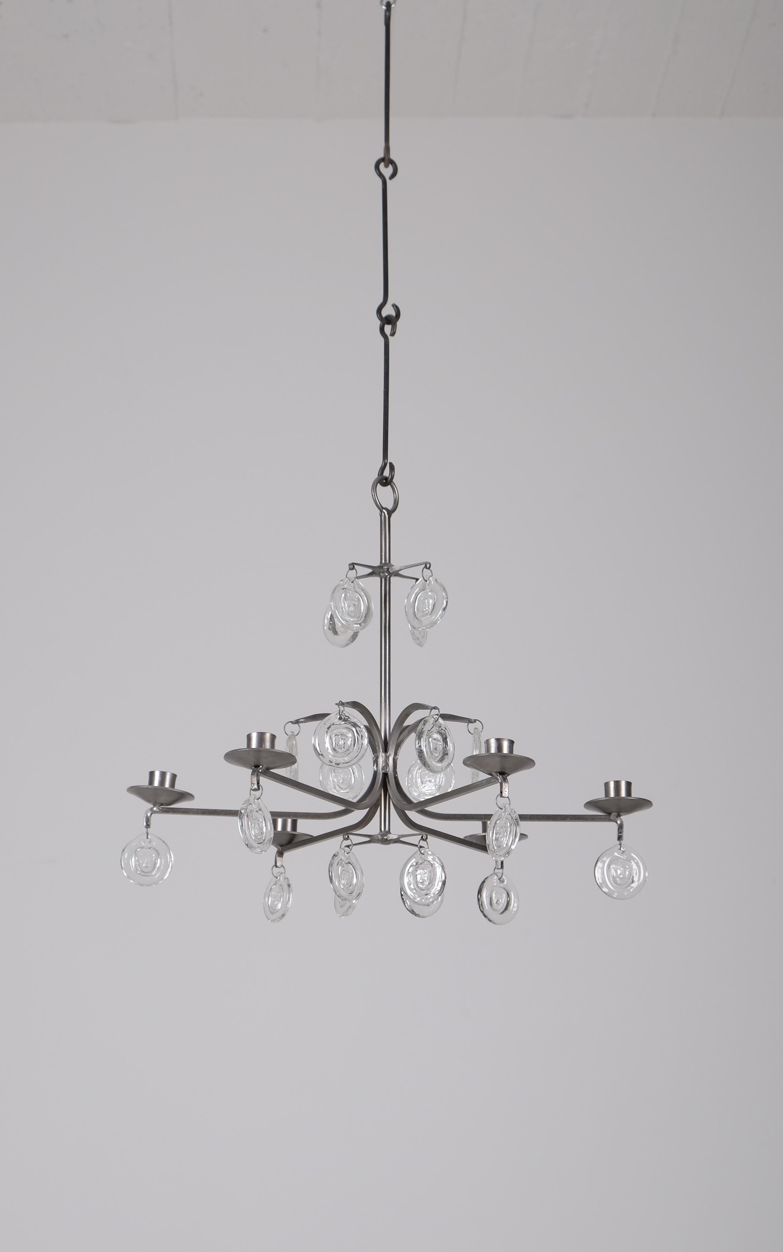 Un lampadario vintage di Erik Höglund, prodotto in Svezia negli anni '70.
Ciondoli in ferro battuto dorato e vetro fuso con diverse figure.
 