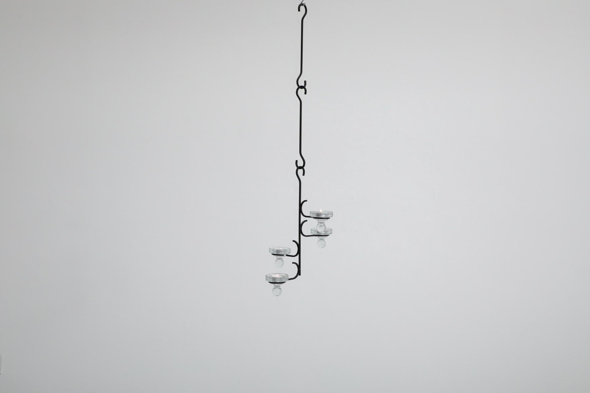 Candelabro con marco de hierro forjado negro, estilo Erik Höglund, de mediados de siglo, con 2 extensiones y 4 vasos de cristal moldeado con clavijas. Las líneas de la pieza comparten grandes similitudes con el trabajo de los aclamados grandes del