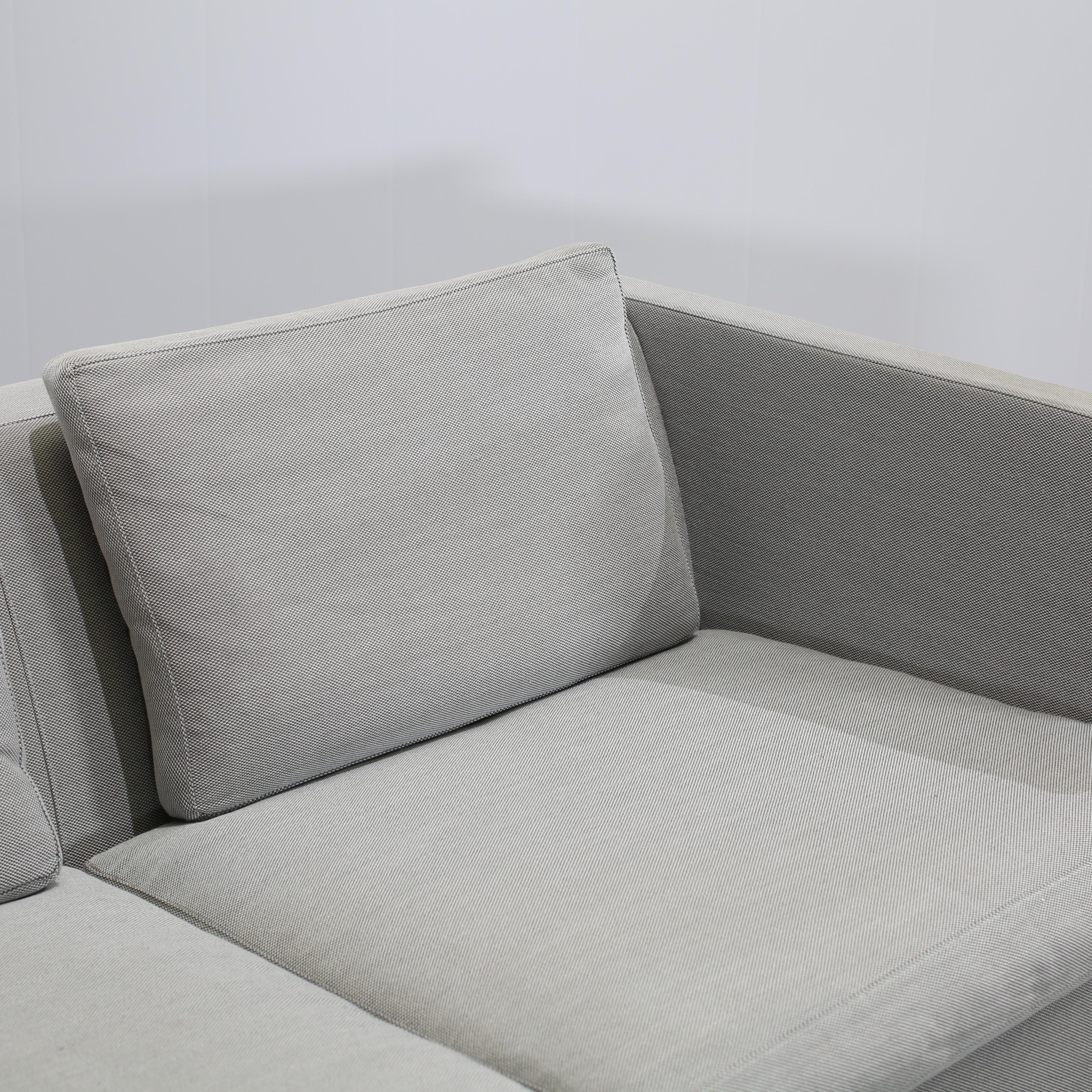 Ti presentiamo l'epitome del lusso e del comfort: il Divano e poggiapiedi in tessuto grigio del famoso designer Erik Jørgensen, realizzato con materiali di alta qualità. L'elegante rivestimento in tessuto grigio aggiungerà un tocco di modernità a