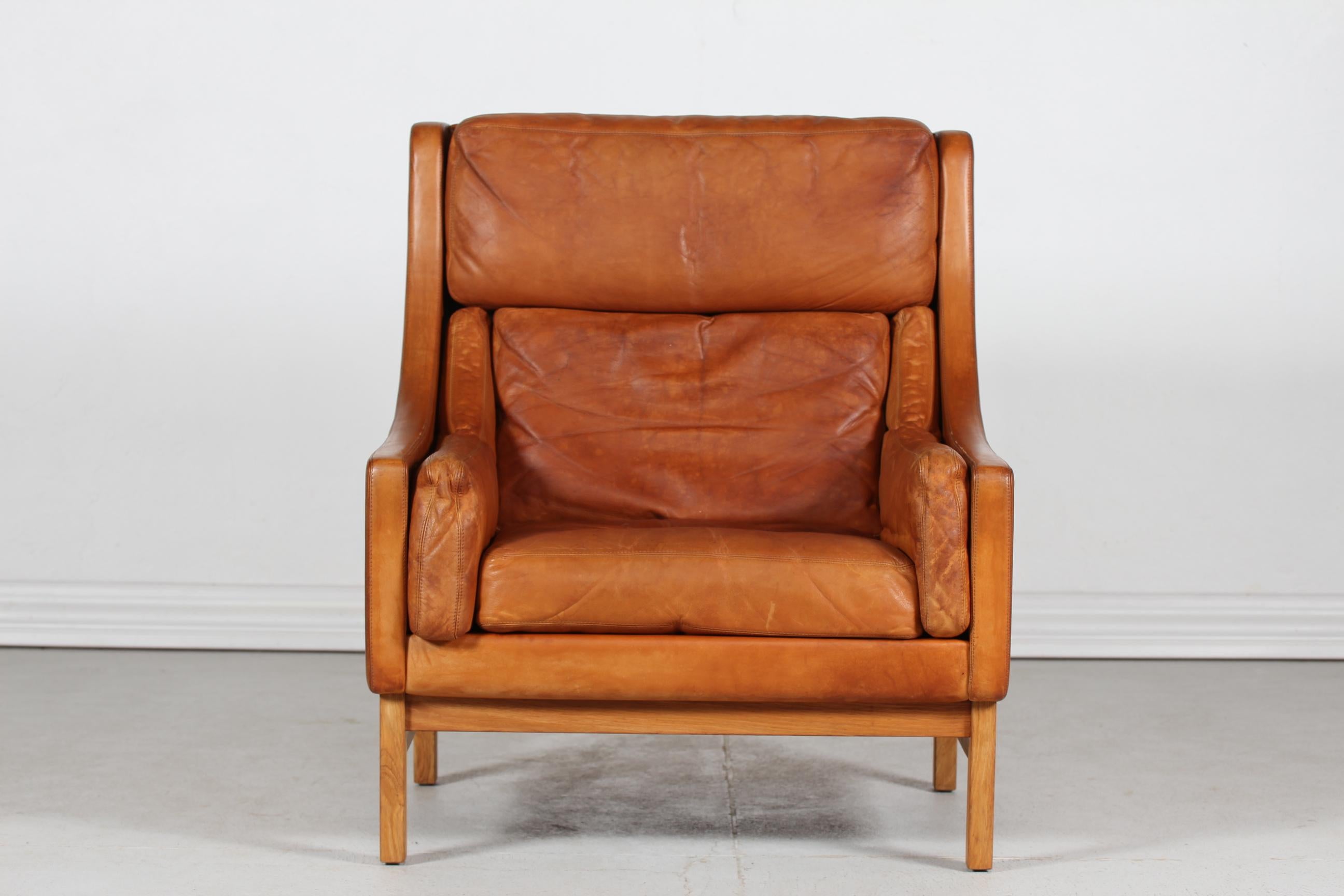 Lounge chair designed by Danish Erik Jørgensen and manufactured at Erik Jørgensen´s own furniturefactory in Denmark in the 1970s.
In the style of Poul Volther

The chair is upholstered with cognac colored patinated leather with great patina 
on