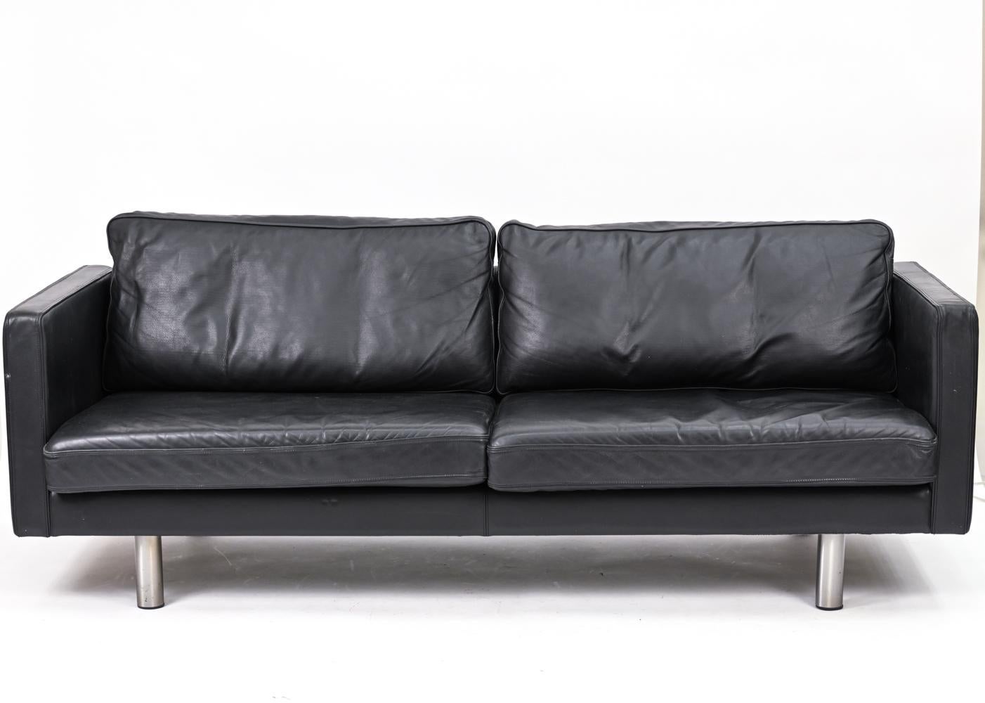 The epitome of the Scandinavian modern box sofa, Erik Jorgensen's EJ220 A sofa features two long seat cushions to complement the sofa's long linear form. In supple black leather with steel legs. Designed in the 1970's, this sofa is continually