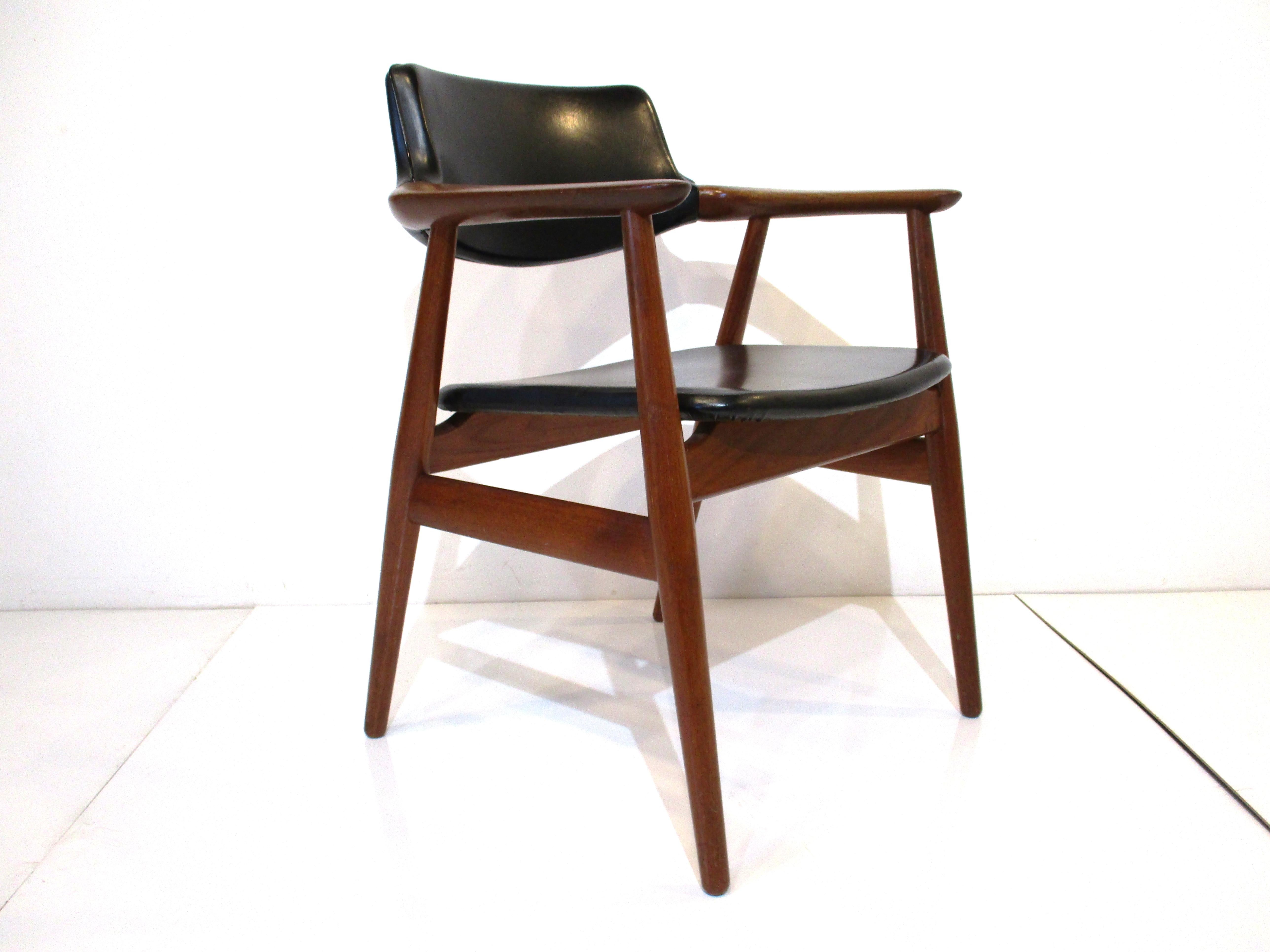 A very well crafted and comfortable desk chair with solid teak frame with the seat and back wrapped in a black leatherette. Designed by Erik Kirkegarrd for Hong Stolefabrik Denmark and bought directly from the Povl Dinesen Copenhagen showroom in