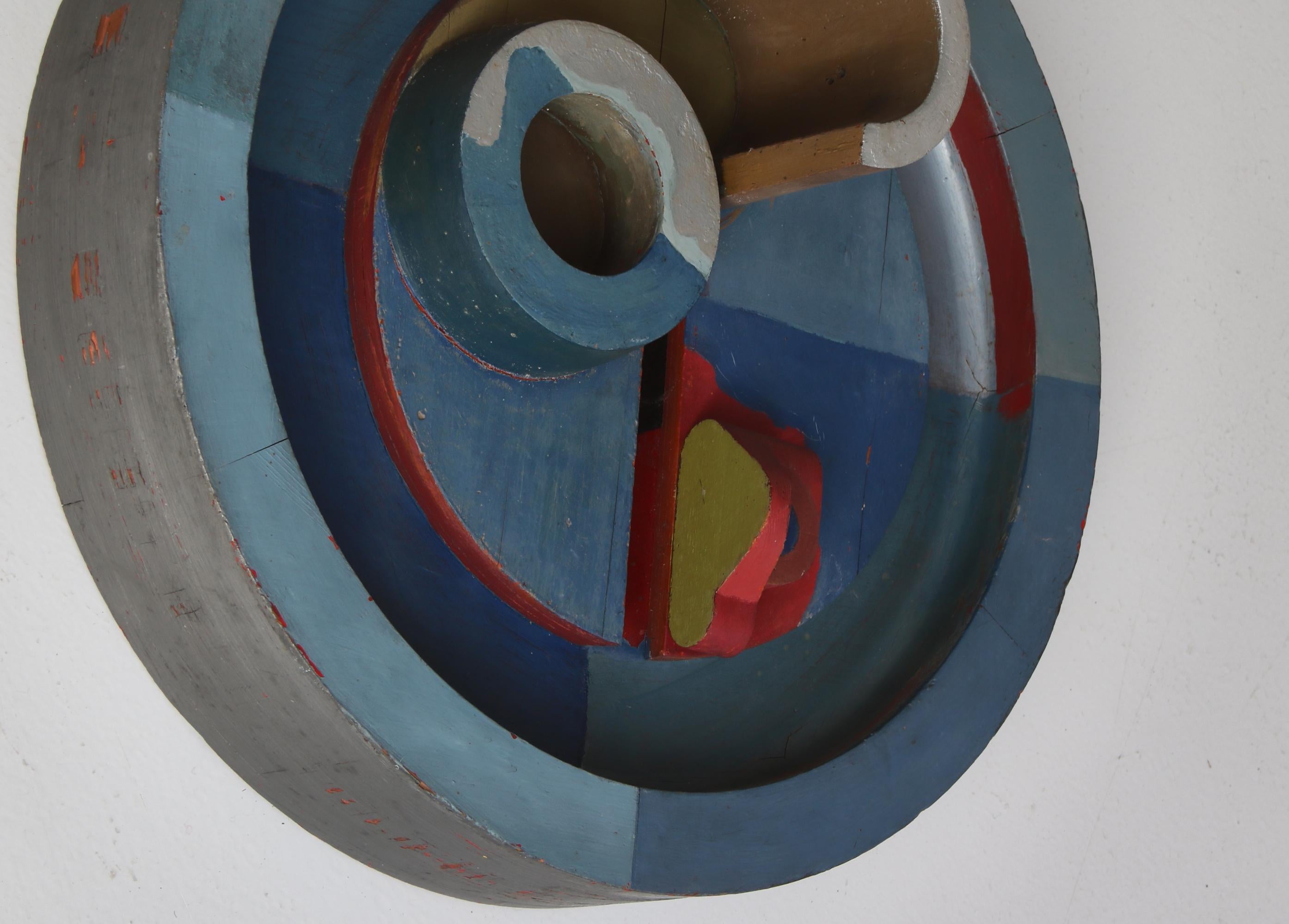 Playful abstract artwork by Danish artist Erik Lagoni Jakobsen made at his own workshop in 1968. The work consist of different found object mounted on a circle and painted. It is inspired by surrealism and dadaism and is typical for Jakobsens works