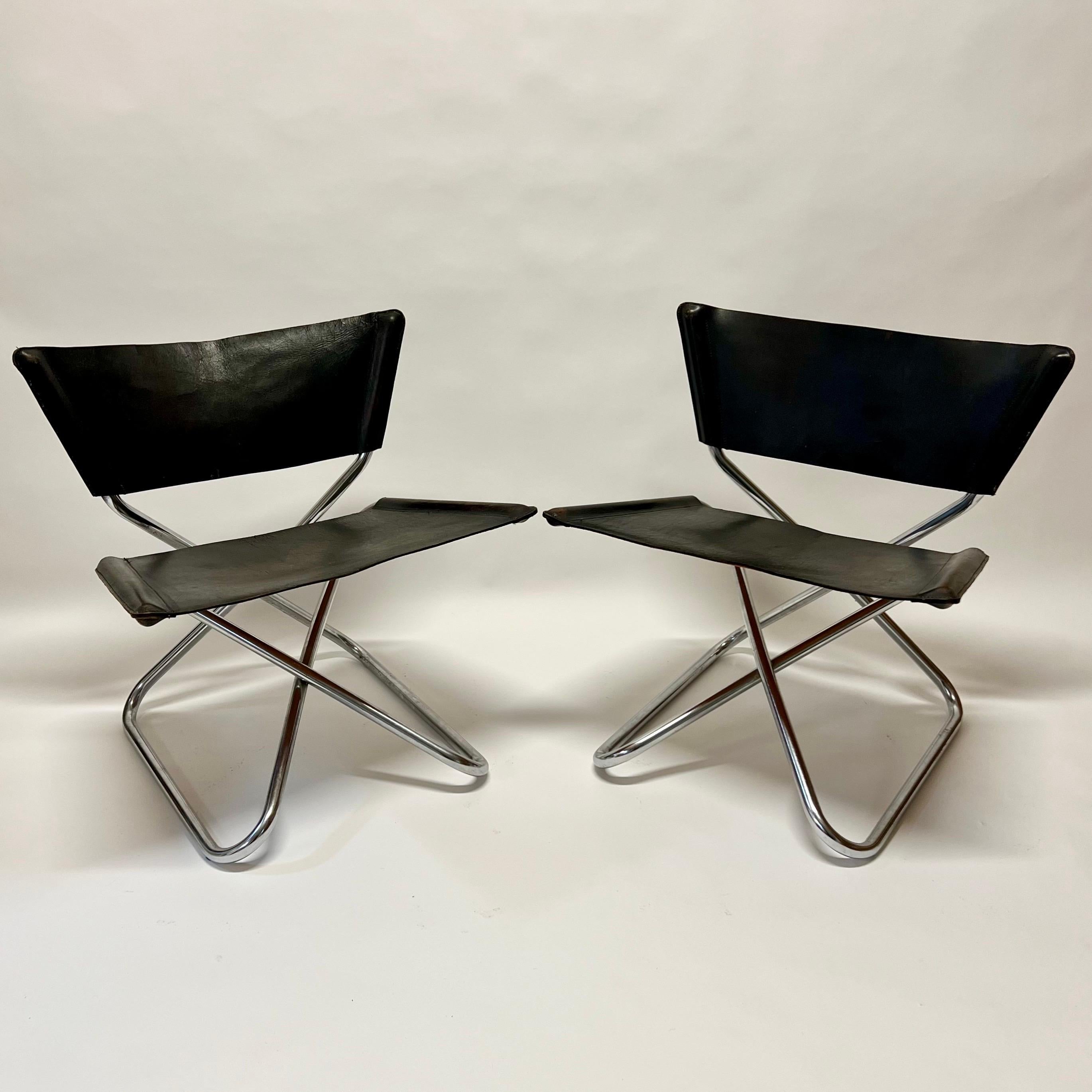 Absolutely fantastic pair of easy lounge chairs with original thick saddle leather seat and seat back. Amazing patina on the leather. These would be a dark brown leather. Incredibly comfortable, as you can see in photo 11. Because they fold, the