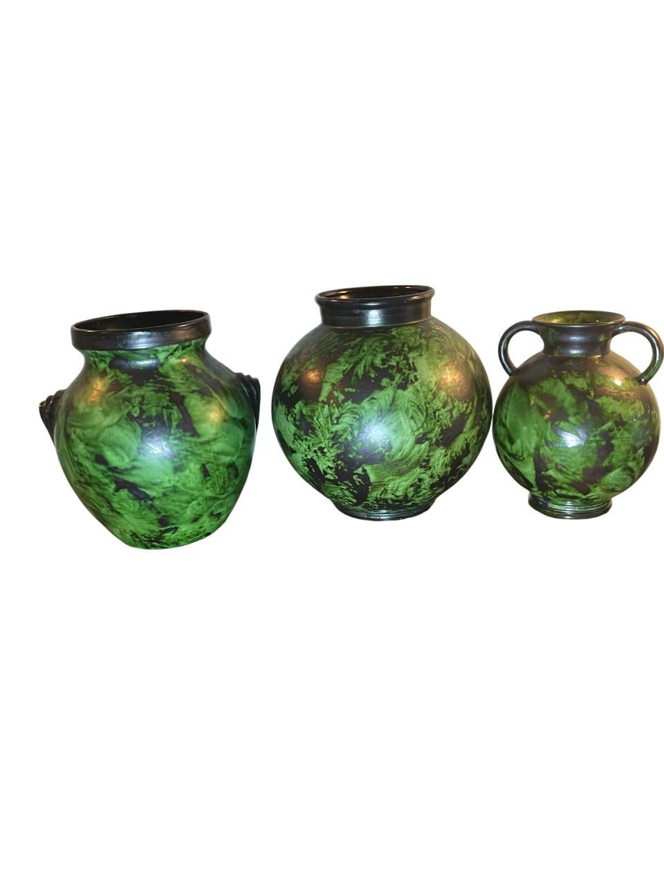 Un trio captivant de vases en céramique conçus par Erik Trio pour Nittsjö Keramik dans les années 1930. Ces poteries d'art suédoises présentent une riche glaçure marbrée verte et noire, caractéristique des premières œuvres de Mornils. L'ensemble