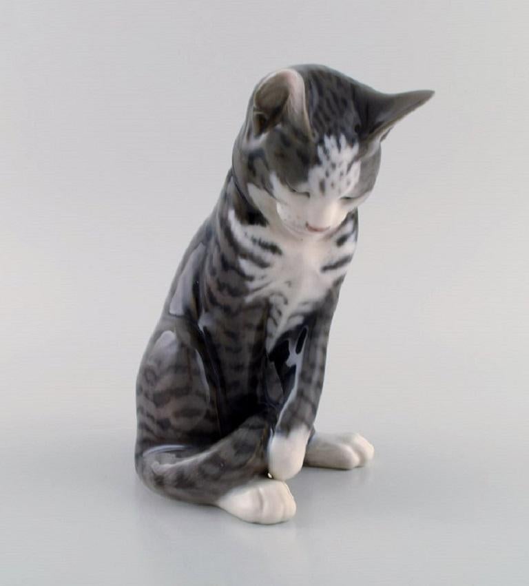Erik Nielsen for Royal Copenhagen. Porcelain figure. Grey-striped cat. 
Model number 1025/340. Dated 1950.
Measures: 18 x 15 cm
In excellent condition.
Stamped.
1st factory quality.