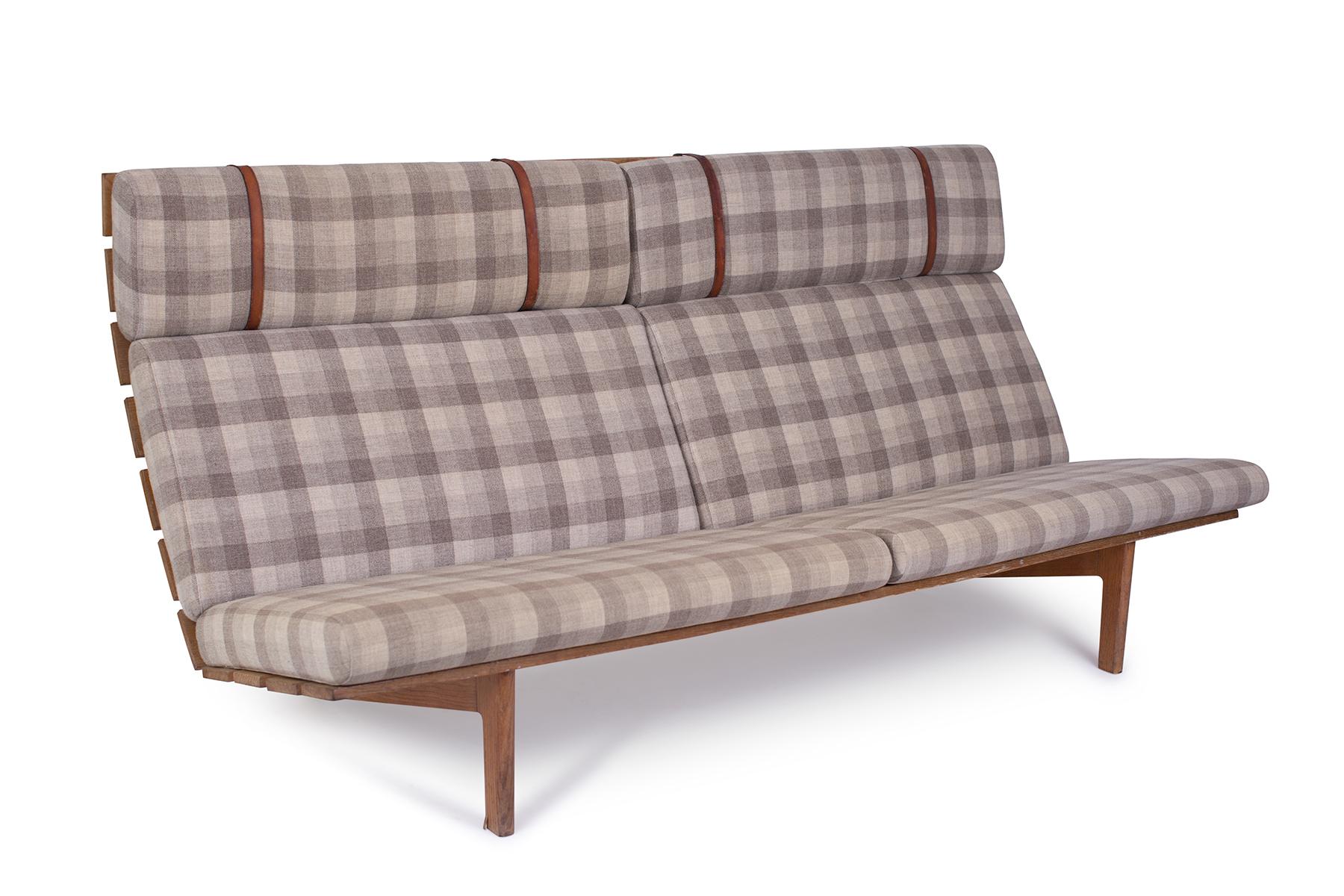 Erik Ole Jorgensen oak and upholstered bench or sofa, circa mid-1950s. This all original example has solid oak planks for the seats and backs. The legs are sculpted solid oak. Upholstery and leather straps are all original. Upholstery could use a