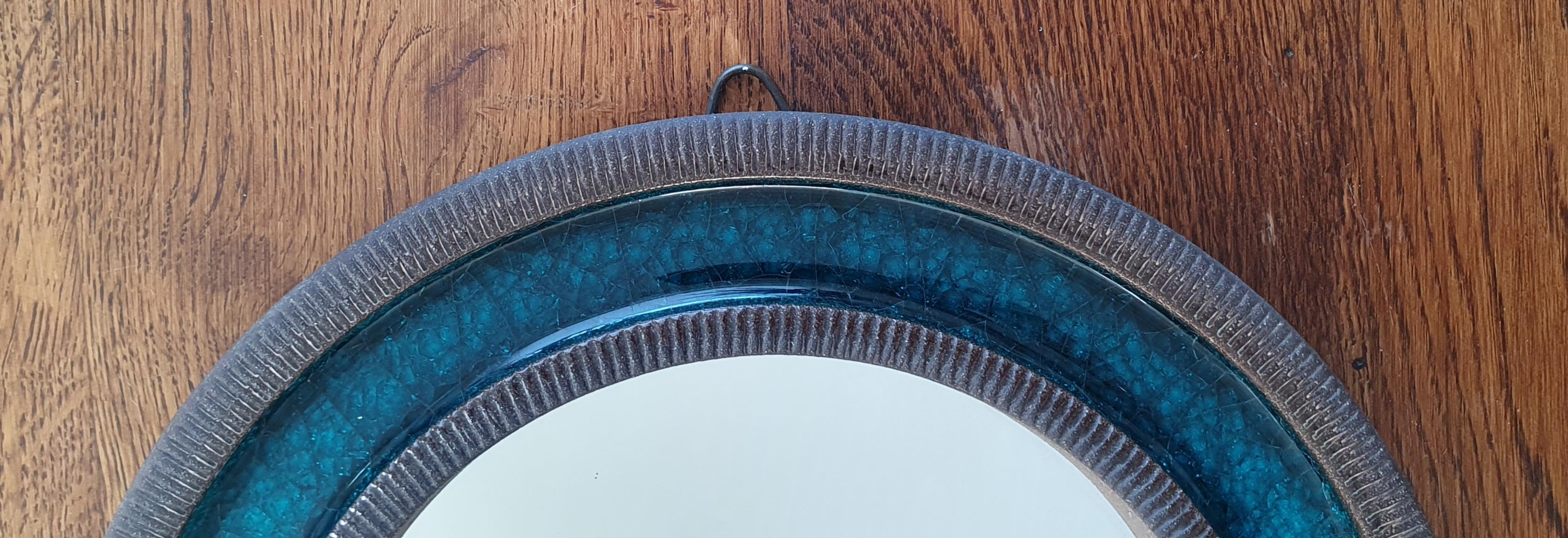 Blue midcentury round ceramic wall mirror designed by Erik Reiff for Danish Knabstrup. The mirror is made of glazed ceramic and has alternating rings with a ceramic ribbed edge and a smooth turquoise/green crystalline glaze on the inside. This color