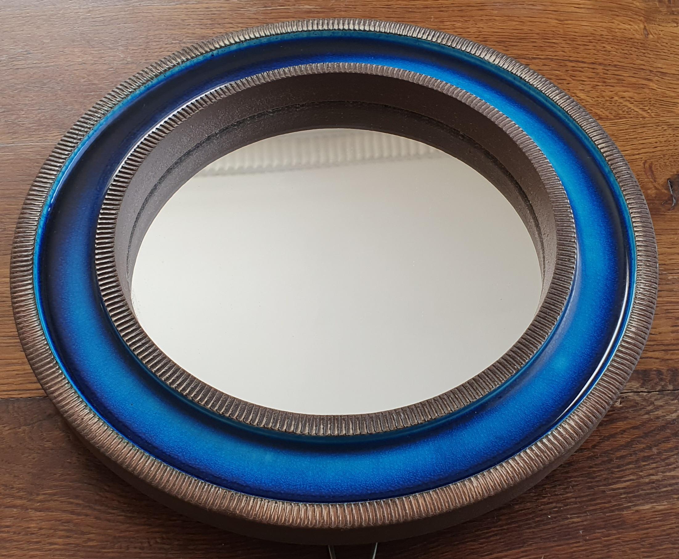Blue midcentury round ceramic wall mirror designed by Erik Reiff for Danish Knabstrup. The mirror is made of glazed ceramic and has alternating rings with a ceramic ribbed edge and a smooth light blue to dark blue crystalline glaze on the inside.