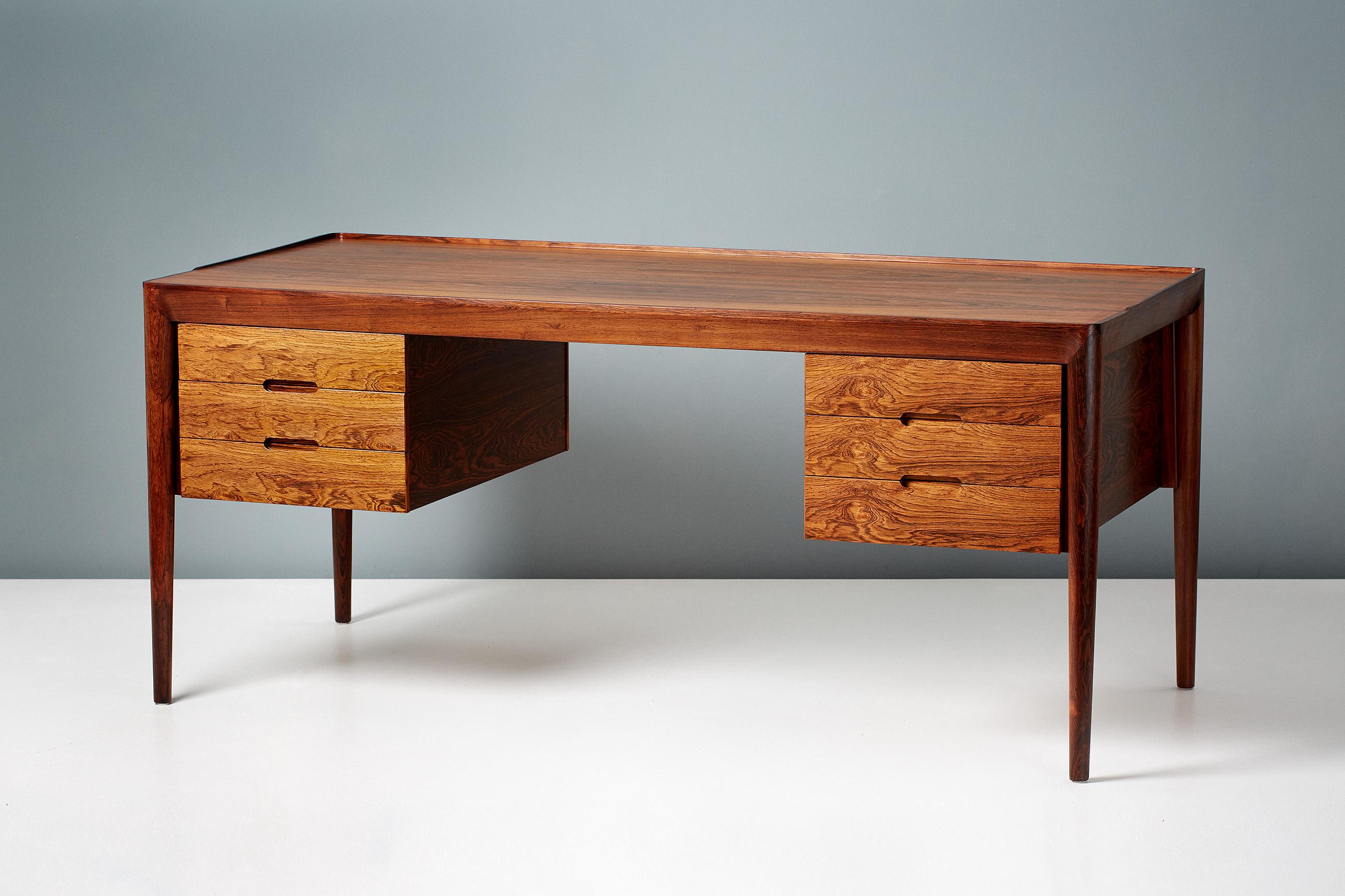 Erik Riisager Hansen writing desk, produced by Haslev Mobelsnedkeri in Haslev, Denmark, circa 1950s. The top is rosewood veneer with solid rosewood legs and mouldings. Each side has a 3-drawer carcass with pullout / pull-out trays.

Measures: H